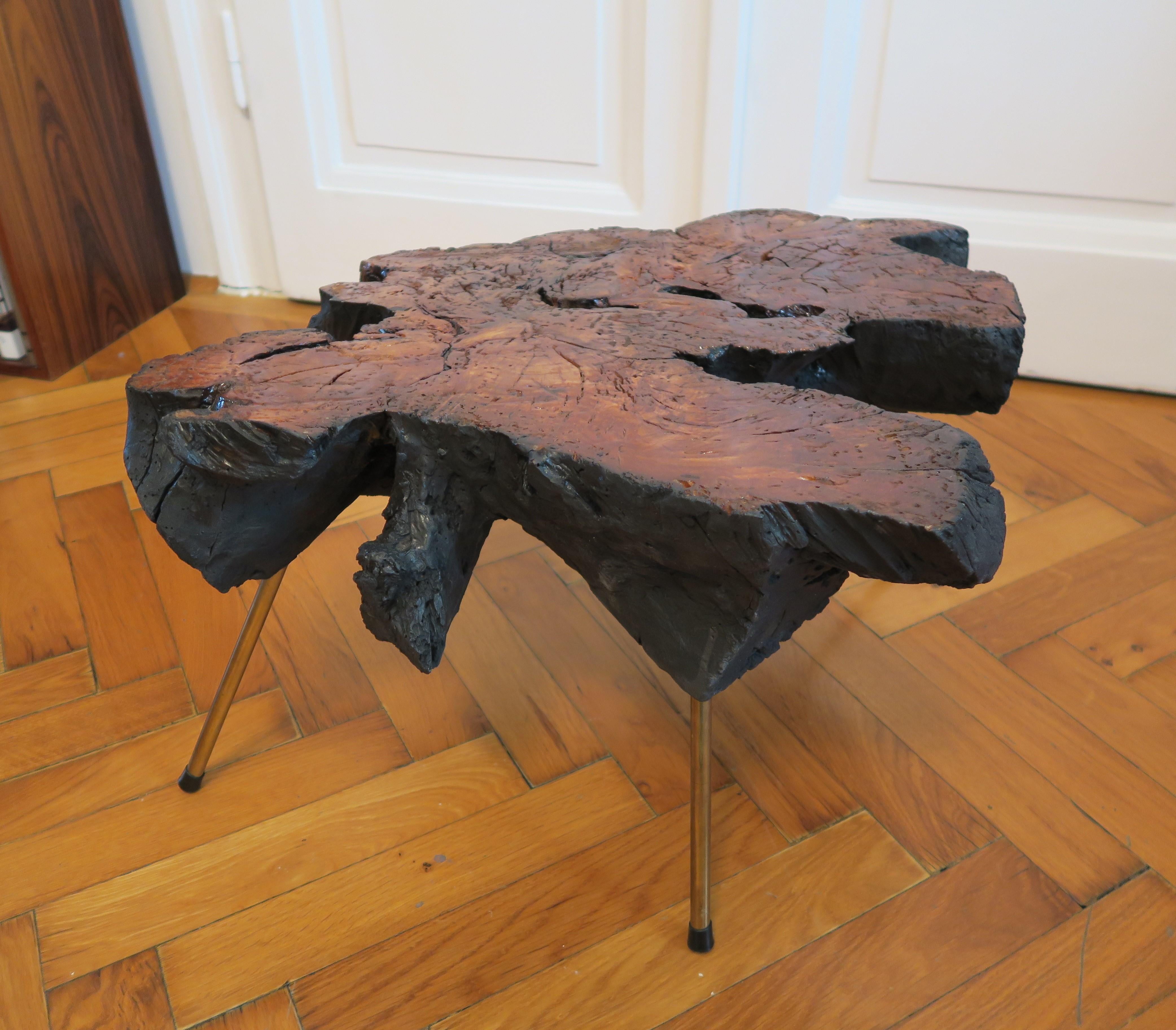 Exzentrischer Beistelltisch im Stil von Carl Auböcks berühmten Baumstammtischen. Die Platte ist aus Holz gefertigt und in ihrer ursprünglichen Form belassen. Die Oberfläche wurde lediglich geglättet und poliert. Die Beine sind aus Messing und werden