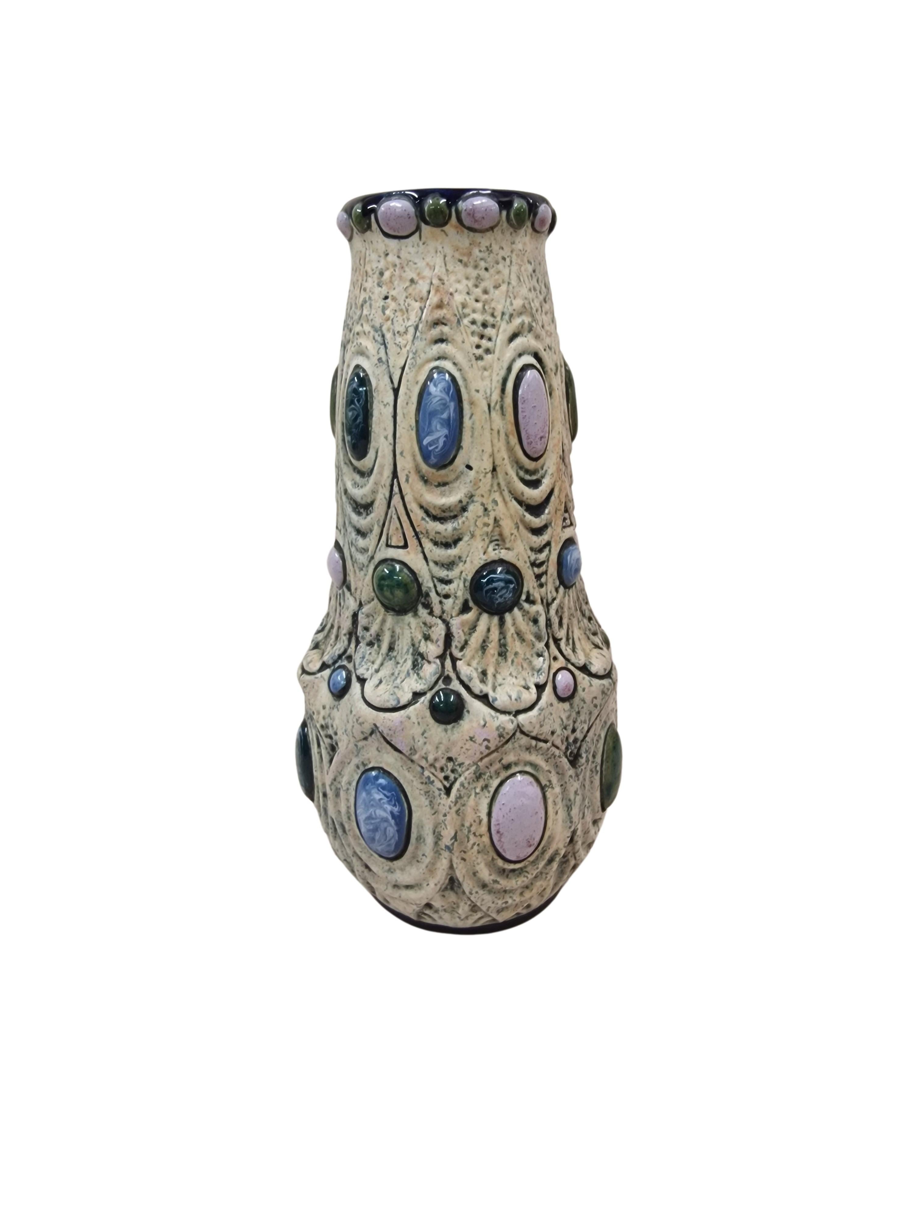 This magnificant flower vase is from the well-known Austrian-Czech manufacturer Amphora, made around 1920.

The vase has a classic shape, a round base and round opening. The light base color is structured by light waves that are interrupted by round