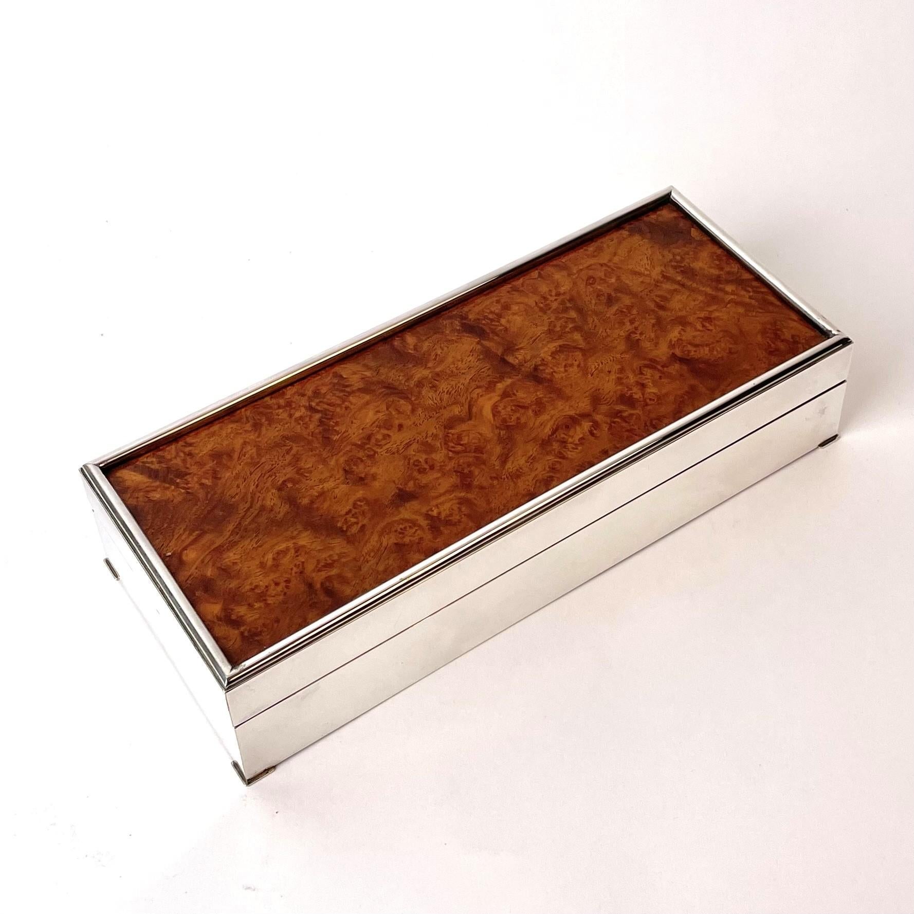 Extremely elegant box by Christian Dior. Made in silver-plated brass with a root top. Mid 20th Century. The box is marked Christian Dior, Made in France on the bottom.

The bottom with some wear and scratches (see pictures), but the visible parts