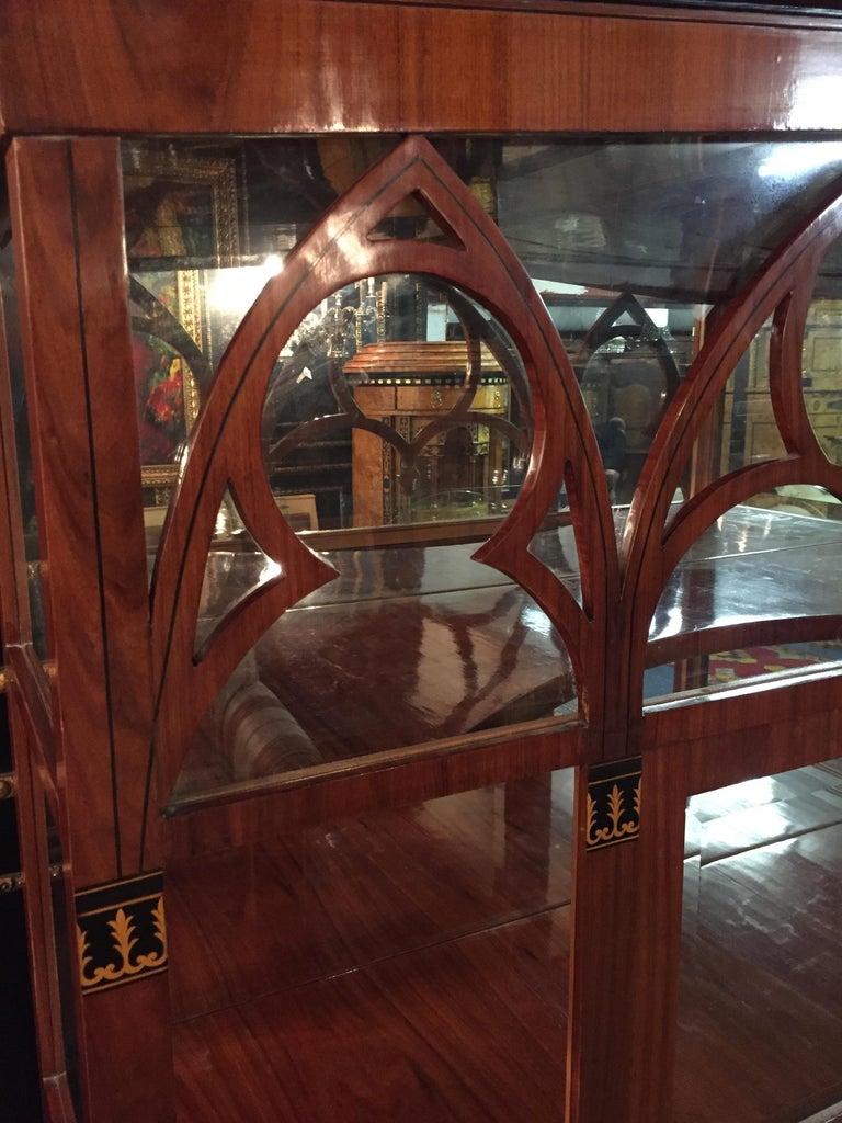 High quality mahogany on solid softwood. Architecturally structured front decorated with neo-Gothic elements. Three-sided sprouted glass body, all windows and in the back wall are mirrors with handcut facets. Floors mahogany veneered and polished on
