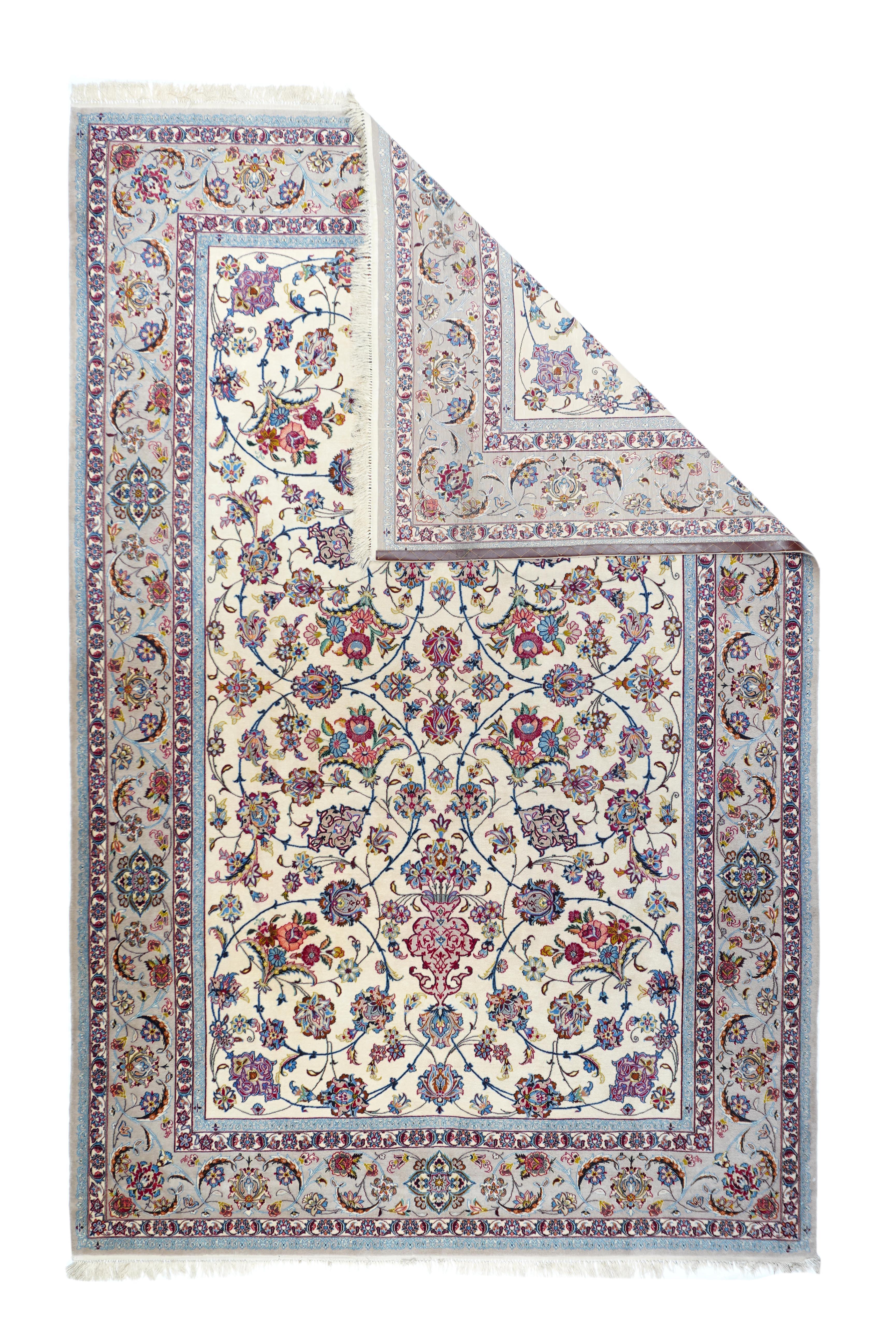 Tappeto persiano Isfahan in lana e seta, estremamente fine, 7'0'' x 10'0''. Un motivo allover simmetrico a quattro vie, composto da viti, palmette e vasi arabescati, adorna uniformemente il campo avorio, mentre il bordo principale verde