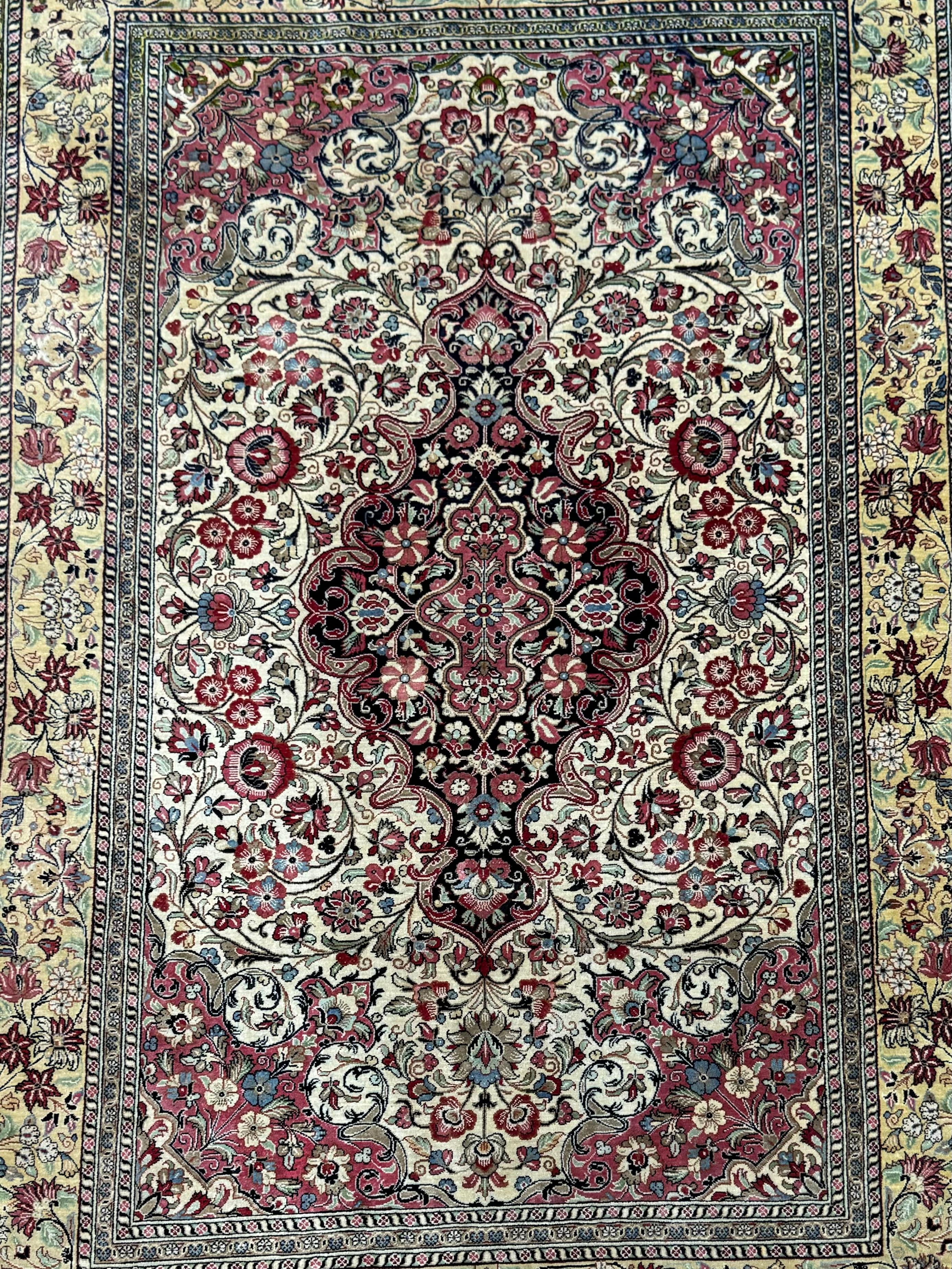 A truly stunning Extremely Fine Persian Silk Rug that originates from Iran in the mid-20th century. This rug is in excellent condition considering its rich history and has beautiful color combinations to match its design! 