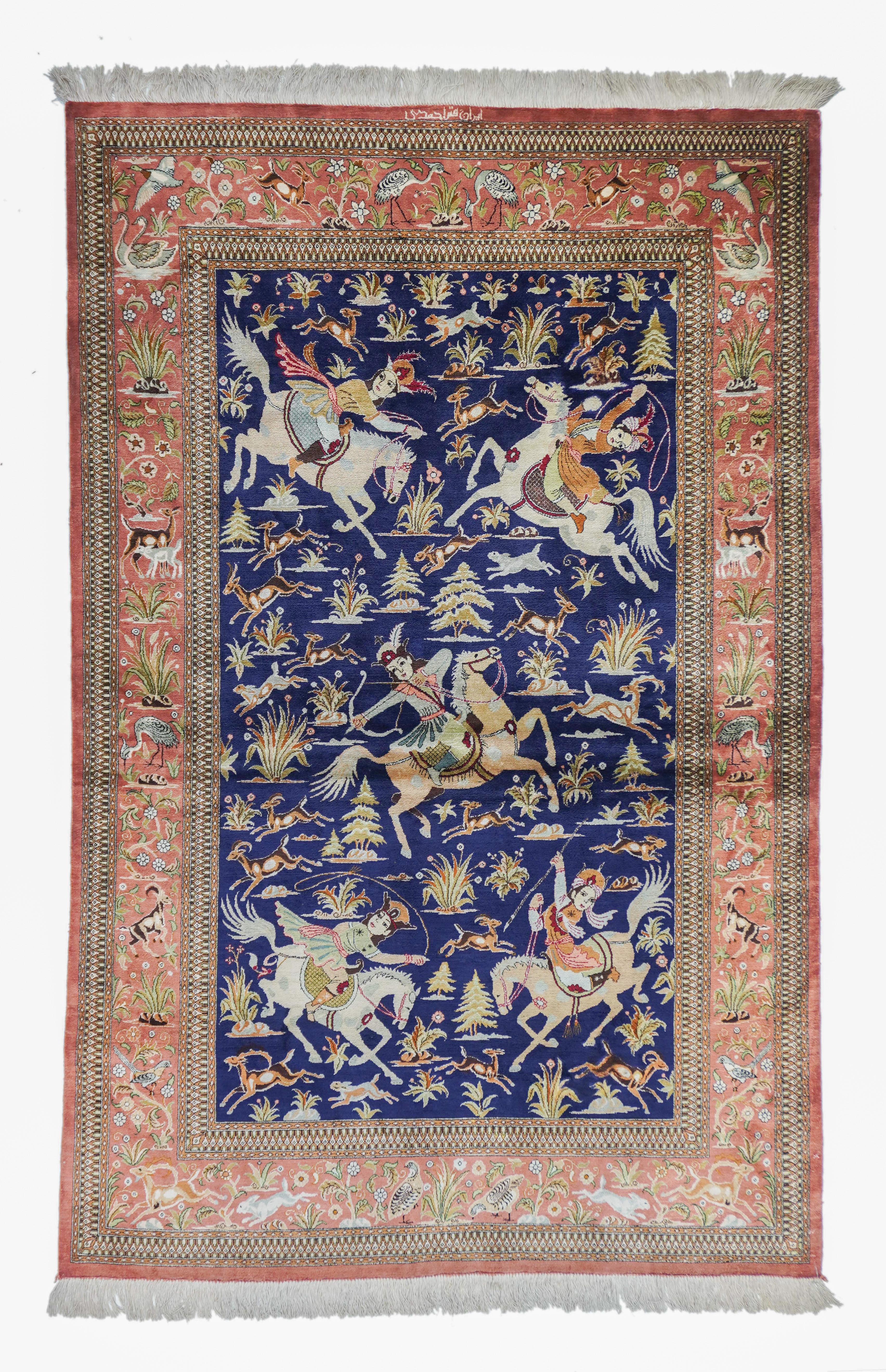 Although Persian silk rugs with hunting themes go back to the 16th century, most are from the 20th, with generally light backgrounds. Rarer are the dark blue ones, as here, with five noble mounted hunters attacking gazelles and antelopes, in a