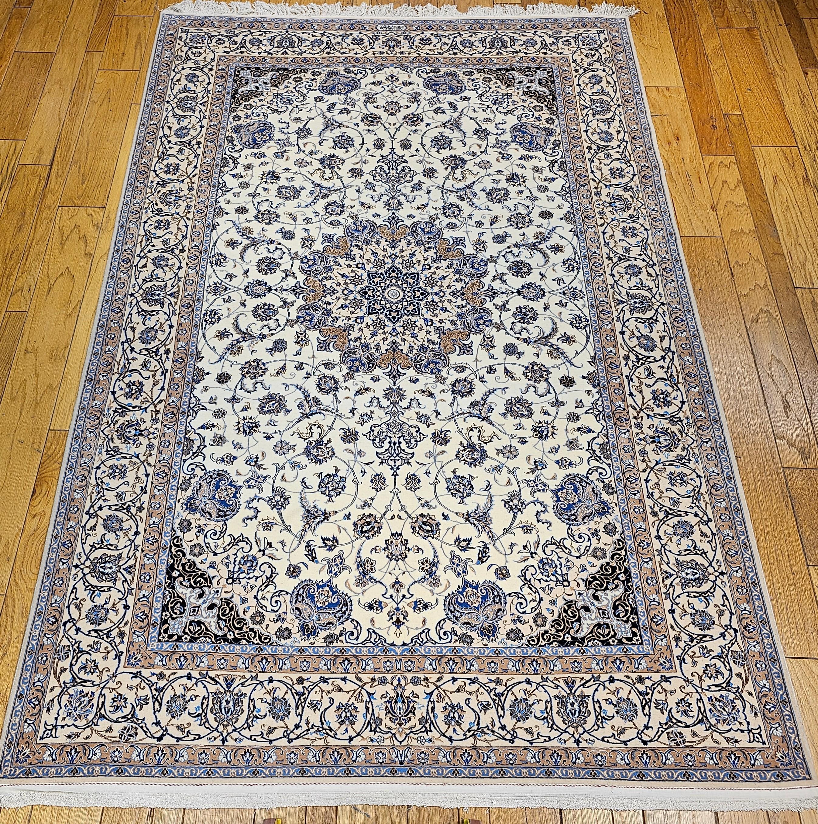 An extremely fine weave handwoven Nain area rug from the 4th quarter of the 1900s.  The Nain Habibian is in an ivory background, with a pale tan border and design accent colors in French blue, pale brown, and ivory colors with silk highlights