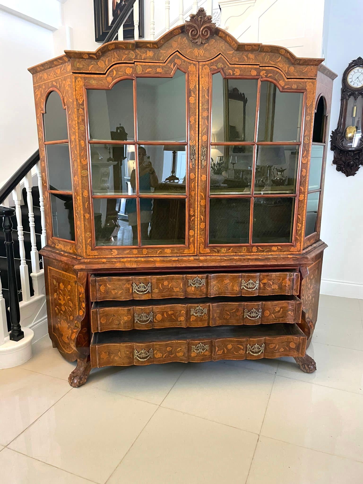 Extremely large antique early 19th century quality burr walnut Dutch floral marquetry inlaid display cabinet having a shaped marquetry inlaid and carved cornice above a pair of astral glazed floral marquetry doors opening to reveal two display
