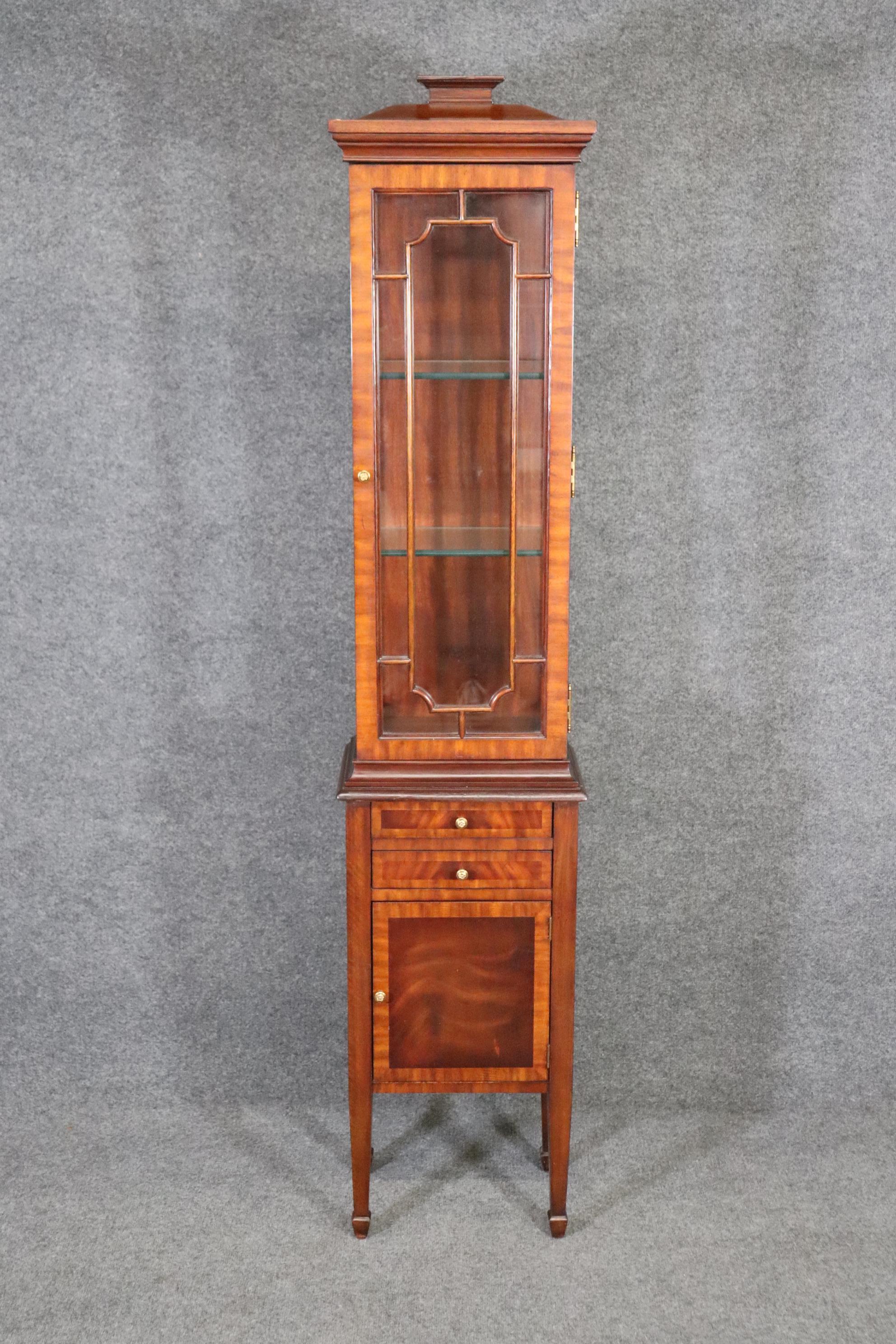 This is a gorgeous mahogany and glass EXTREMELY narrow vitrine or china cabinet. It's perfect for photos framed of loved ones or small collectibles to display in a limited space. The cabinet is a 2 piece high quality cabinet with a pogoda shaped top