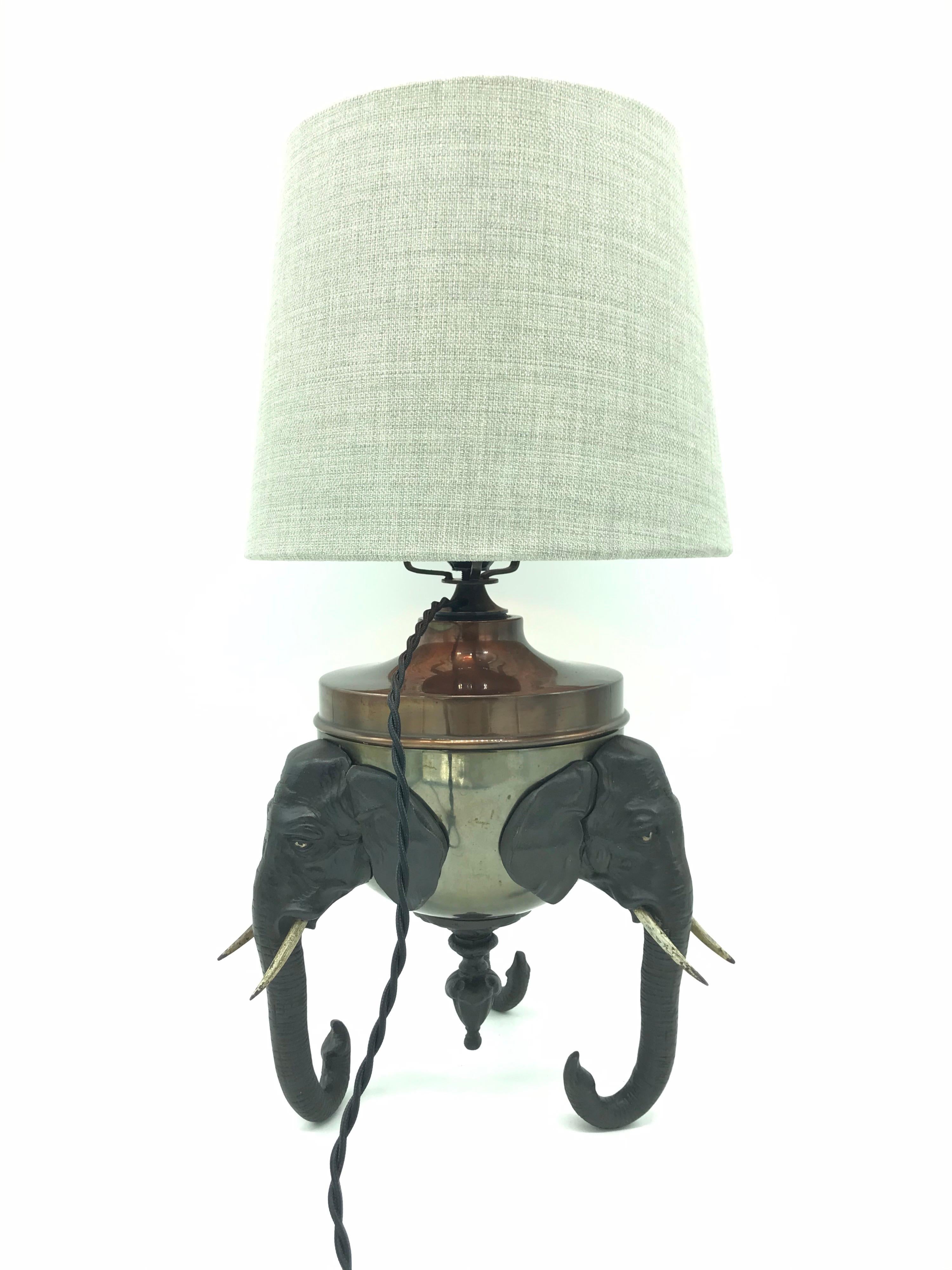 Extremely rare antique elephant oil lamp conversion to a table lamp.
Made of brass and cast iron 
3 elephant heads supporting the lamp on their tusks.
A great English country house look.
Rewired with an antique inline switch.
Can be fitted with an