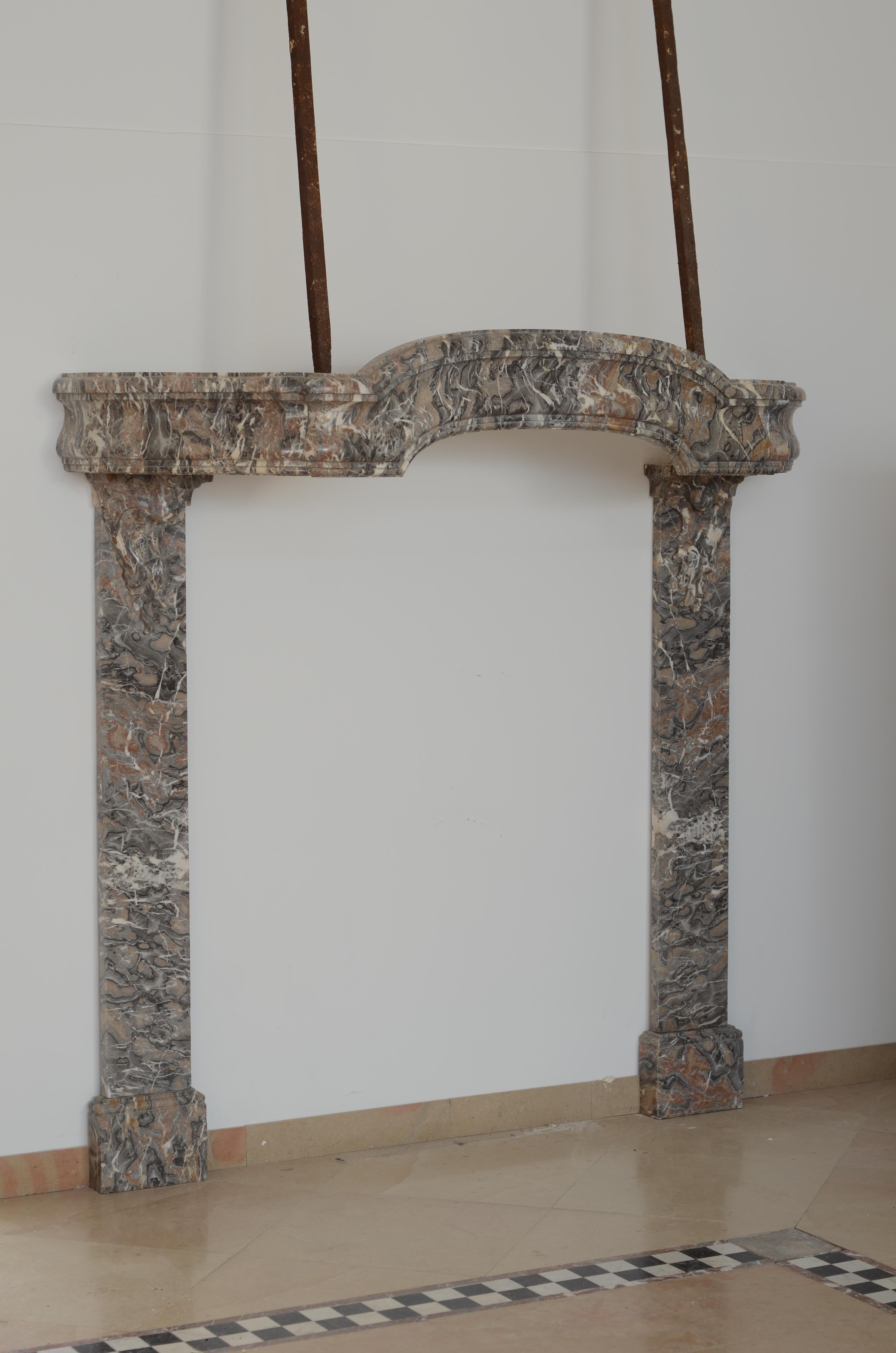 Extraordinary Dutch Louis XIV Smuiger, executed in Gris d'Ardenne marble.
This chimneypiece was made circa 1700 for a small farmers residence in Haarlem.

Simple but beautiful curved and profiles frieze, supported by amazing C-scrolls on matching