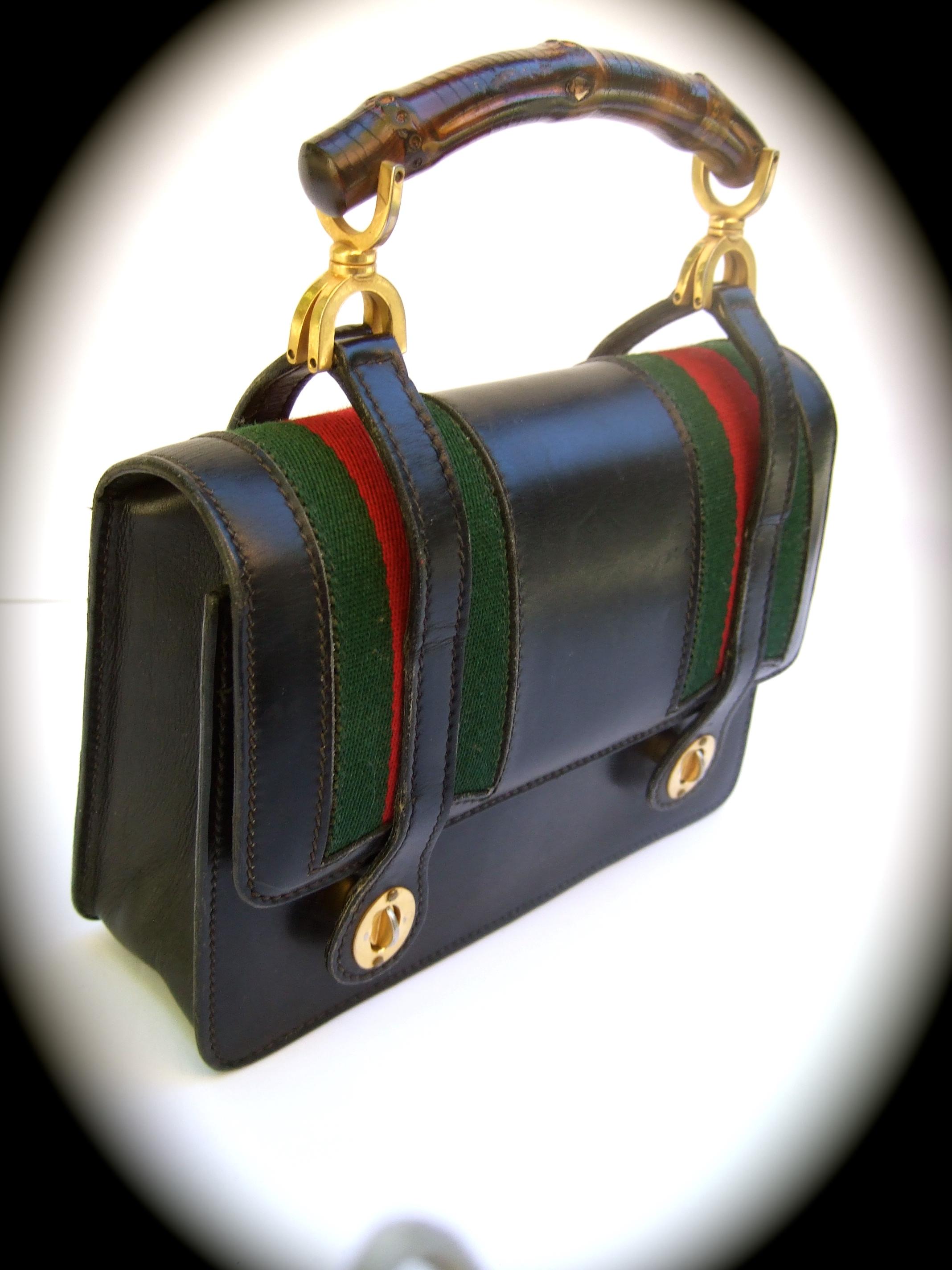 GUCCI Italy extremely rare black leather bamboo handle handbag c 1970s 
The iconic vintage handbag is covered in smooth structured black leather
Paired with an organic wood bamboo handle with their signature 
red & green webbed wool stripes
