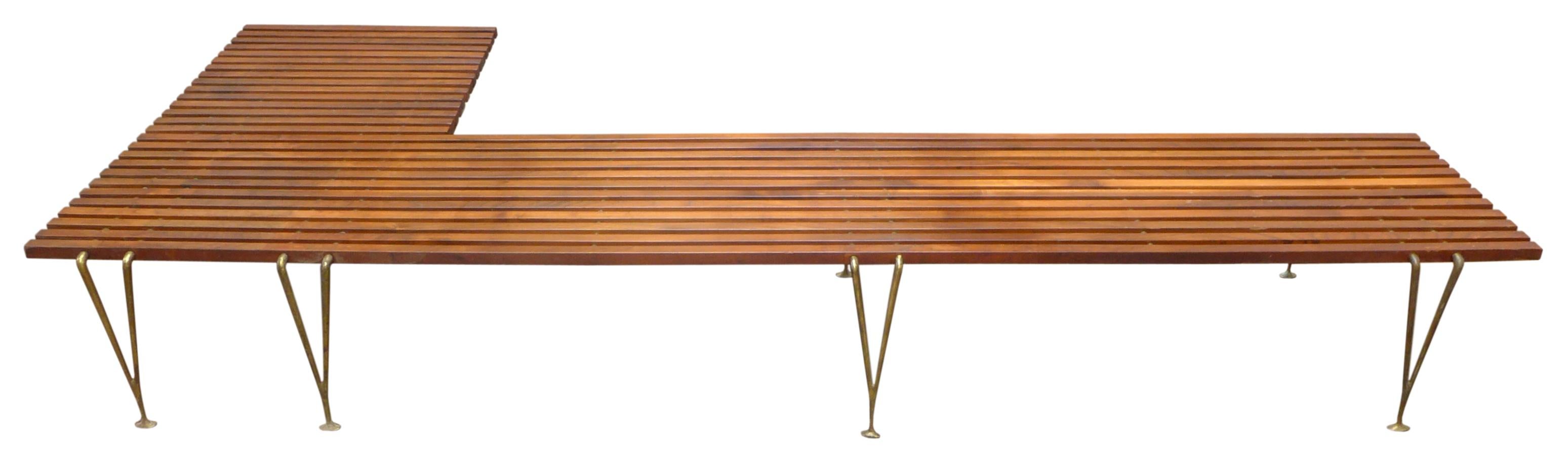 An extremely unusual and possibly unique, L-shaped slat bench attributed to Hugh Acton. Likely a custom commission for a specific residence, as no other examples of this form have been seen. A fantastic design with slatted-walnut surface elements