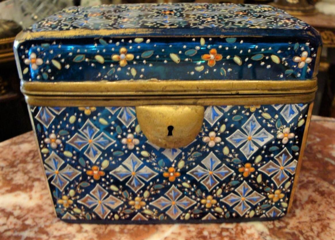 L'objet suivant que nous proposons est une magnifique et rare boîte de Moser du 19e siècle. La boîte de rangement en verre bleu aqua de Moser est ornée d'un motif géométrique en forme de croix en platine et de fleurs de clocher bleues et blanches.