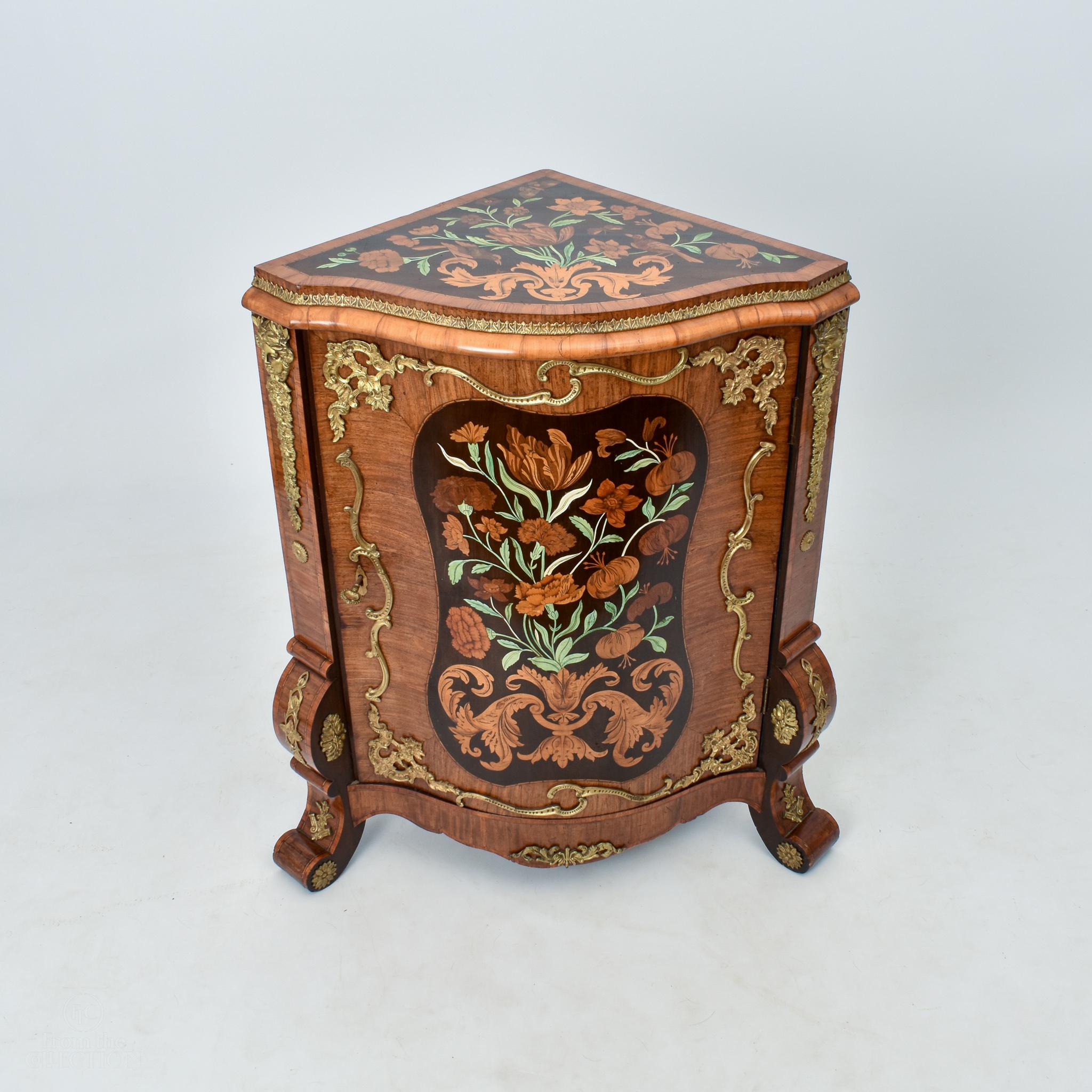 An exceptional testament to the artistry of the late 19th century, these exceedingly rare marquetry corner cabinets, dating back to circa 1880, stand as captivating showcases of intricate craftsmanship. The harmonious marriage of marquetry and