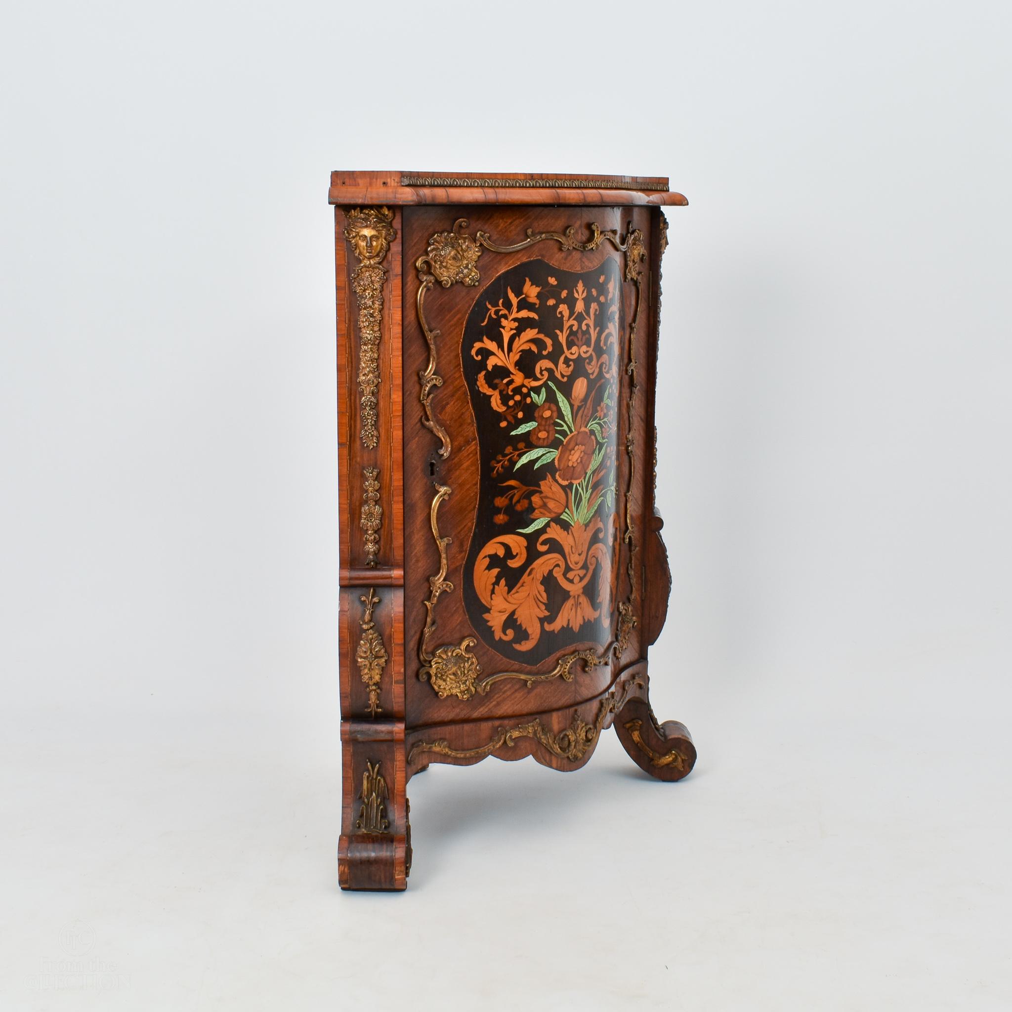 An exceptional testament to the artistry of the late 19th century, these exceedingly rare marquetry corner cabinets, dating back to circa 1880, stand as captivating showcases of intricate craftsmanship. The harmonious marriage of marquetry and