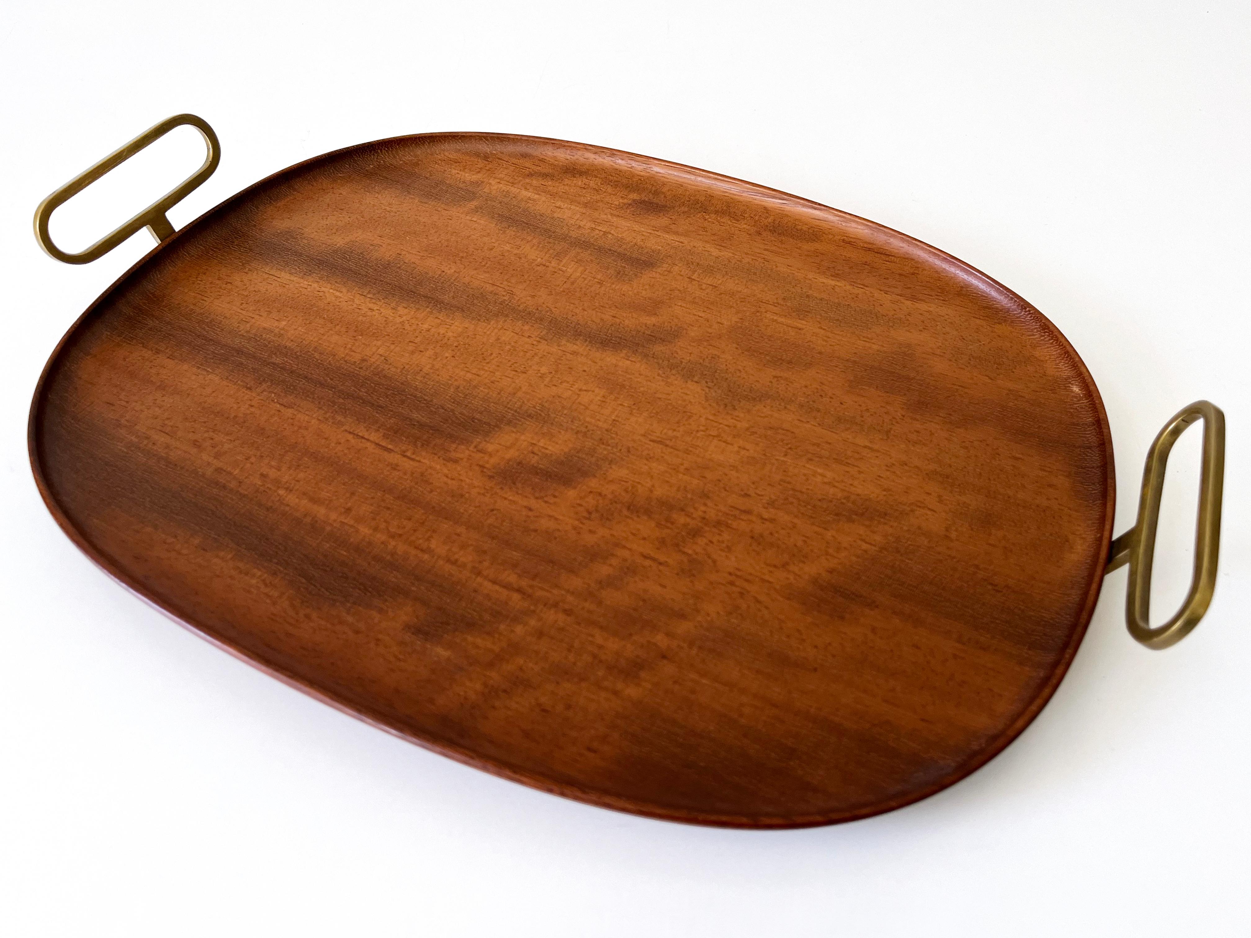Extremely rare and elegant Mid-Century Modern serving tray by Carl Auböck II, Vienna, Austria, 1950s.

Executed in solid teak wood and brass handle.

Dimensions: 
Overall Length: 15.95 in. (40.5 cm)
Width: 11.03 in. (28 cm)
Overall height with