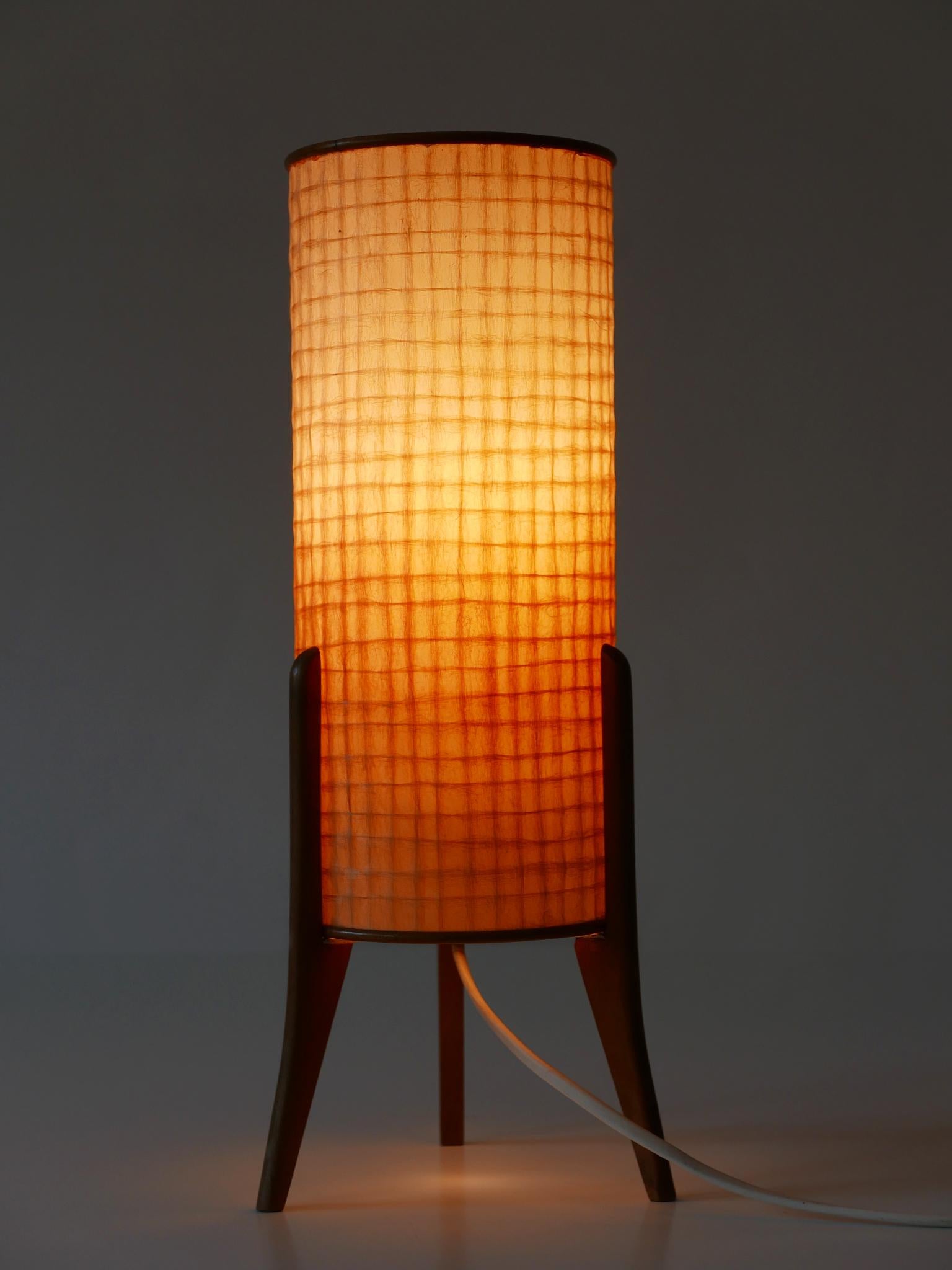 Lampada da tavolo / comodino estremamente rara, minimalista e deliziosa del Mid Century Modern. Progettato e fabbricato in Germania, negli anni '60.

Realizzata in legno, carta pergamena e metallo, la lampada da tavolo è dotata di 1 portalampada a