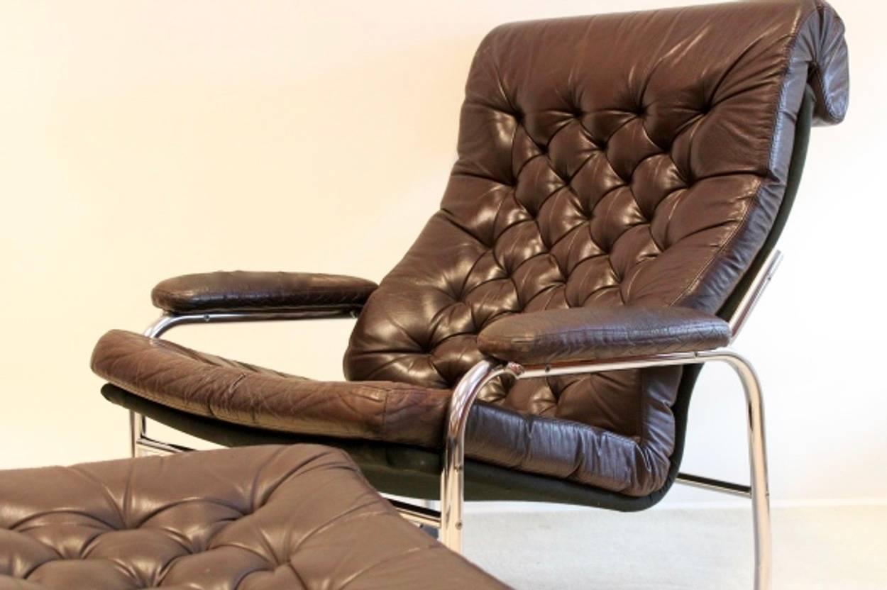 An extremely rare and beautiful 1970s original Noboru Nakamura leather button back lounge chair with matching footstool in chocolate brown leather. The 'Bore' called chair and stool have a light chrome tubular frame both with removable leather