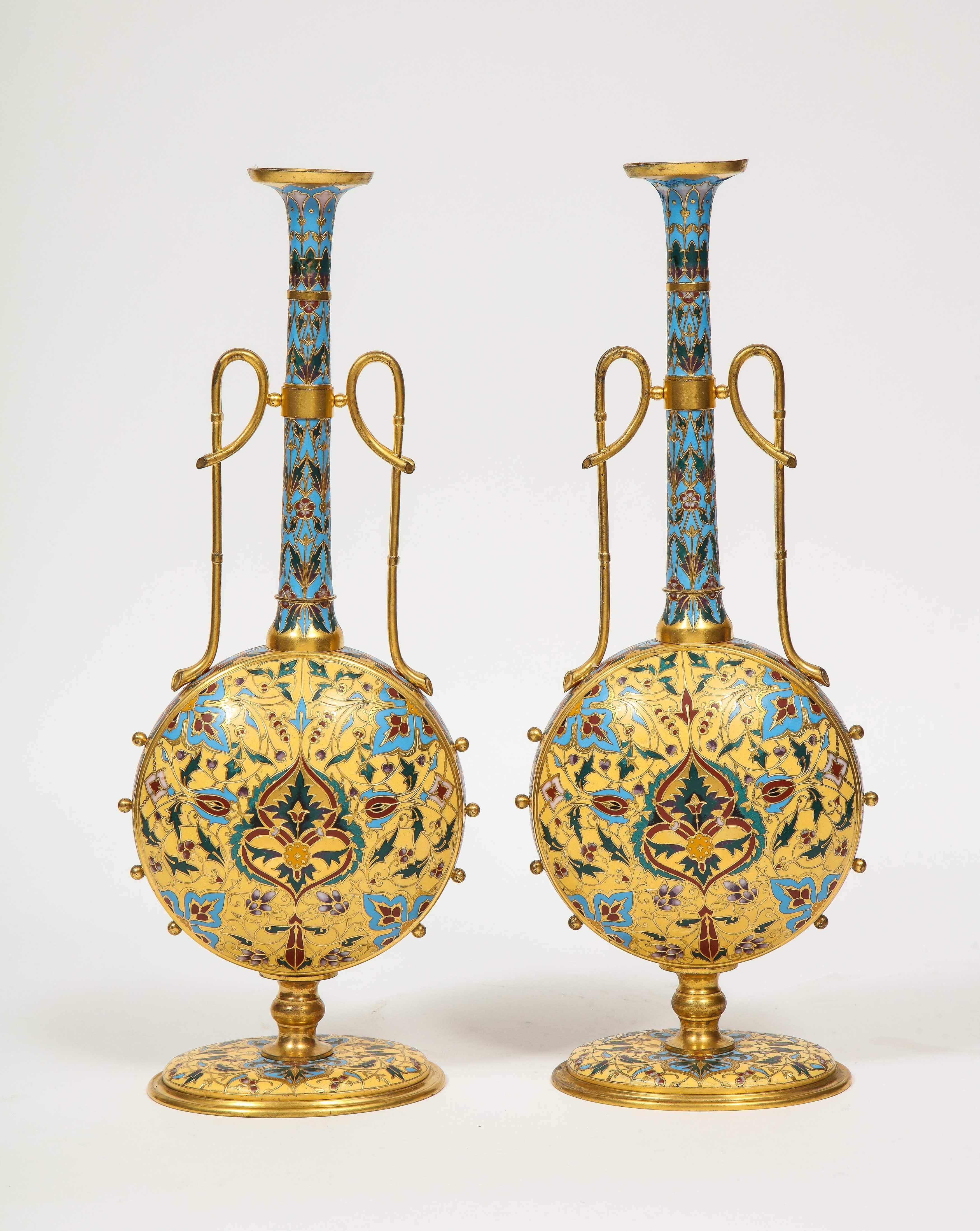 Une paire de vases Ferdinand Barbedienne en bronze doré et émail champlevé, extrêmement rare et de qualité musée, vers 1870, certainement conçue par Louis Constant Sevin. 

Forme très inhabituelle. Émaillé de couleurs vives, dans le goût