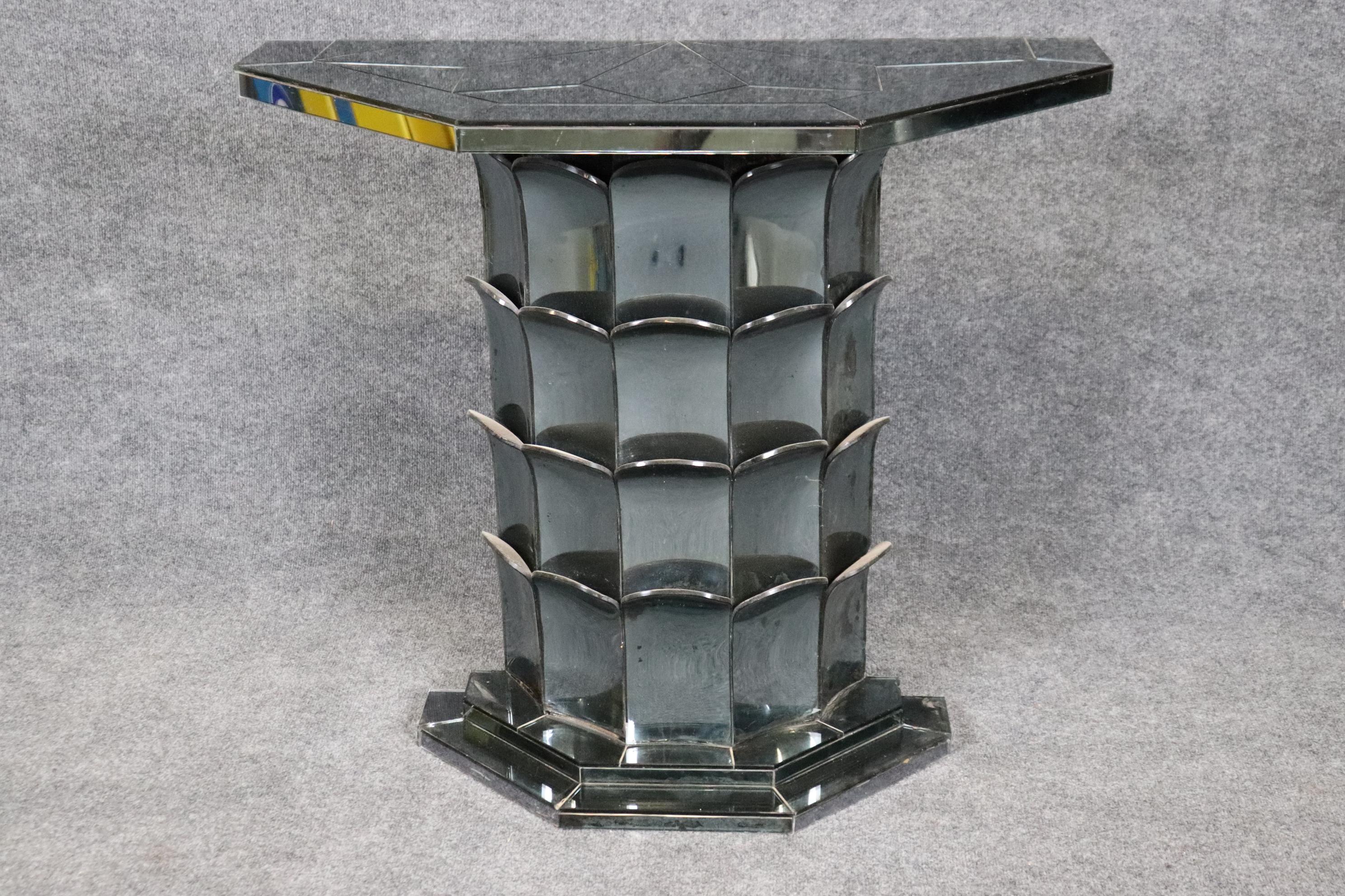 This is an exsquisite and extremely rare form of French Art Deco console table with smoked mirrored glass panels and bent glass leafs or scallop formations. The table is in good antique condition with minor signs of age and use such as patina to the