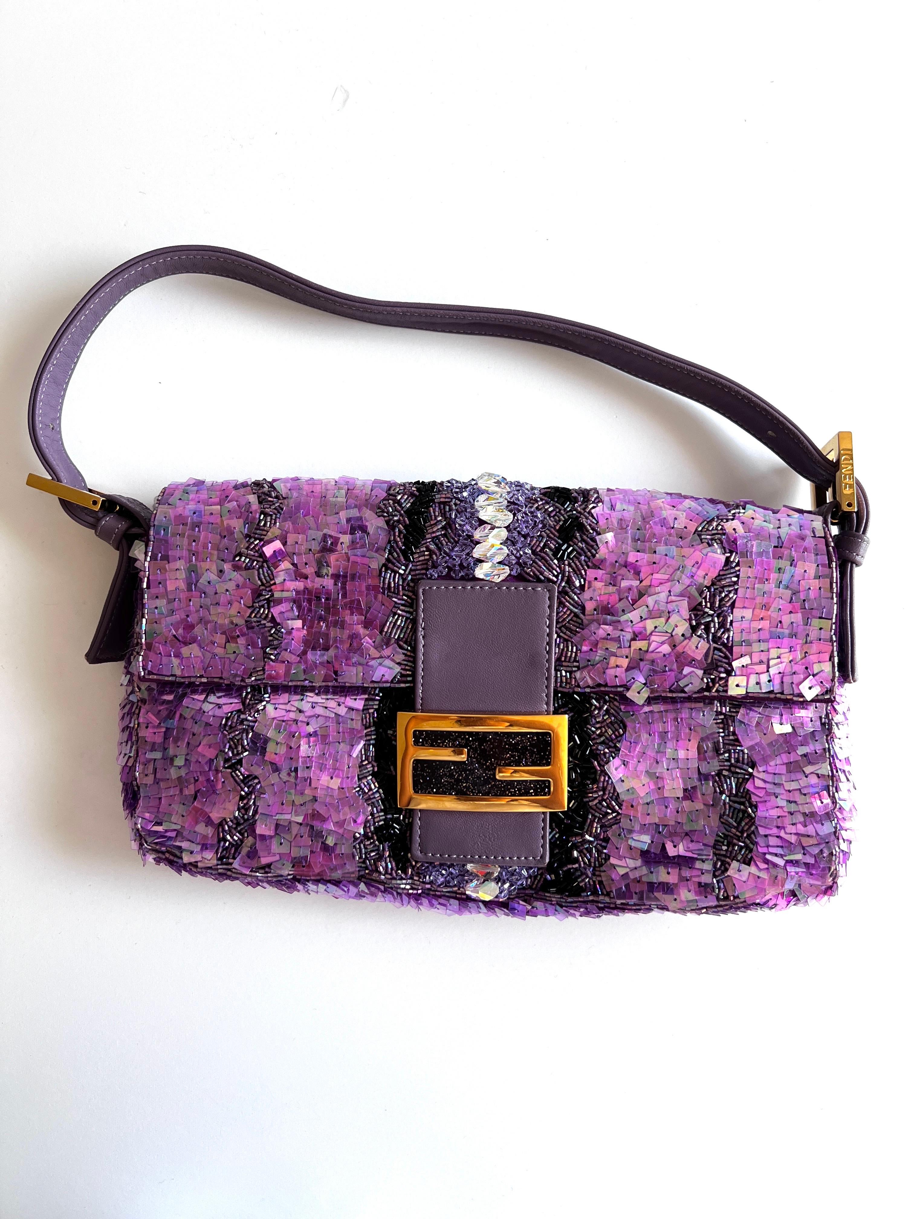 Die Fendi Baguette mit lila Pailletten und Strasssteinen. Diese exquisite, mit viel Liebe zum Detail gefertigte Handtasche ist ein Beweis für die unvergleichliche Handwerkskunst und den Stil von Fendi.

Jede Paillette ist von Hand auf den prächtigen
