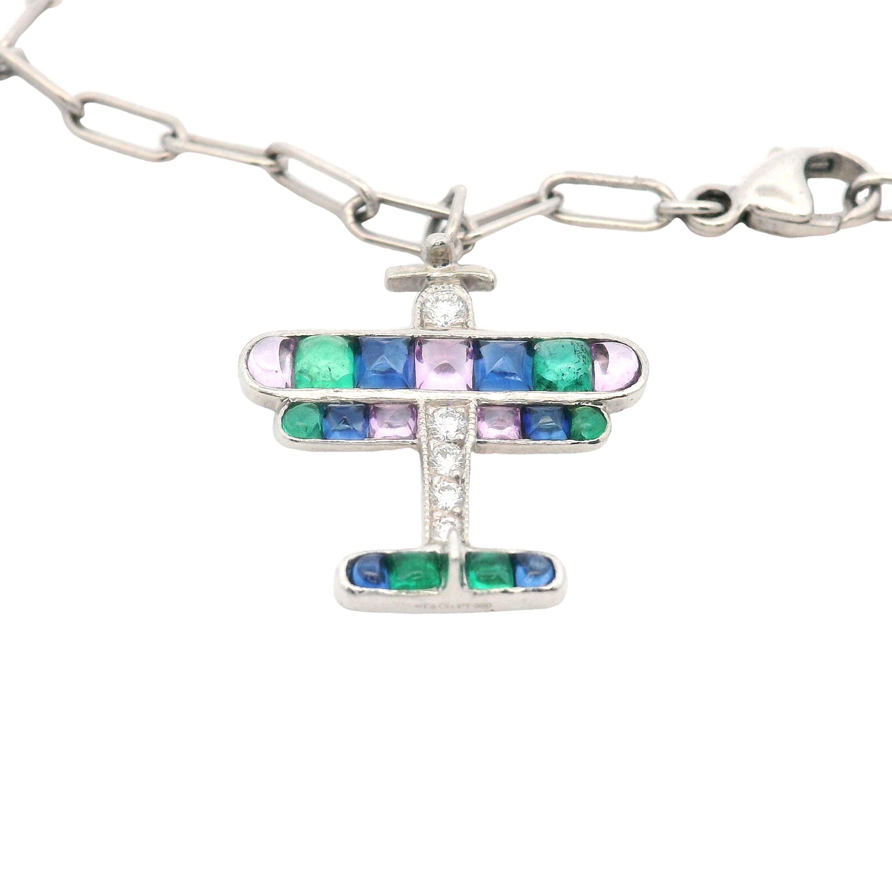 This exquisite late Art Deco platinum charm bracelet by Tiffany & Co. is a rare find, featuring a unique collection of meticulously crafted charms. Each charm is signed and stamped Tiffany and Co. and is a miniature work of art, set with precious