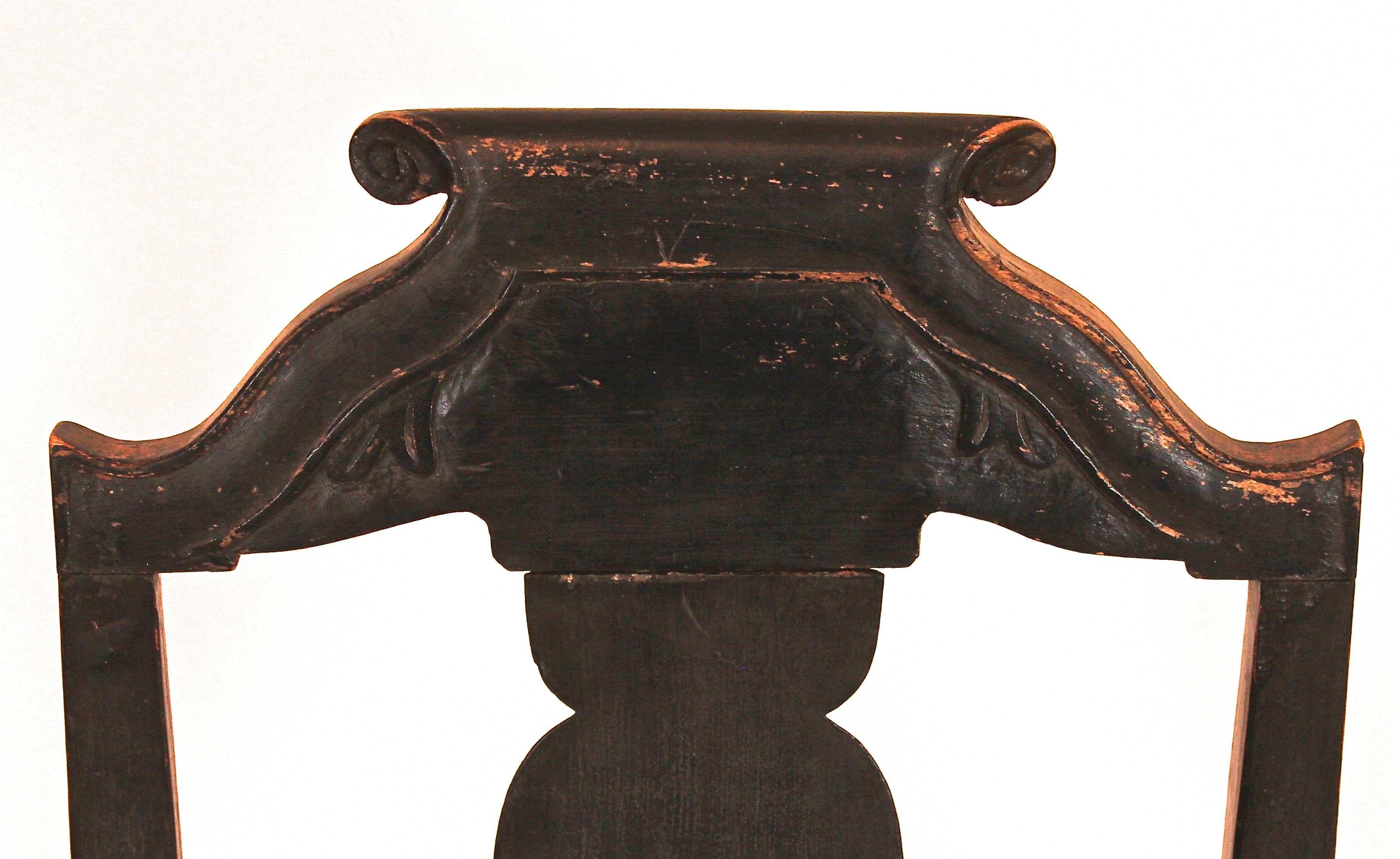 Stepped crest with carved volutes, solid splat, rush seat, turned legs, stretchers and ball feet. Ball and ring front stretcher. Early black paint over original green.
