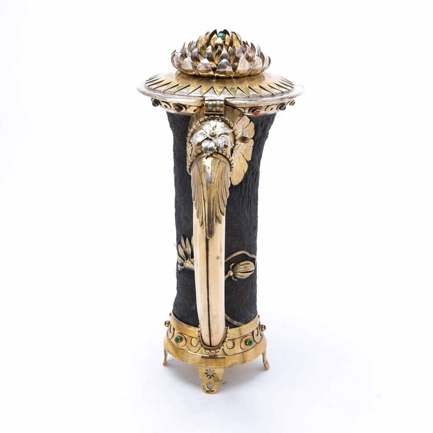 One of the most unusual items we’ve ever come across, an early 20th century water jug or vessel fashioned from hippopotamus leather, a hippopotamus tusk handle, the metalwork depicting flora with a mix of silver plate, copper and brass, decorated