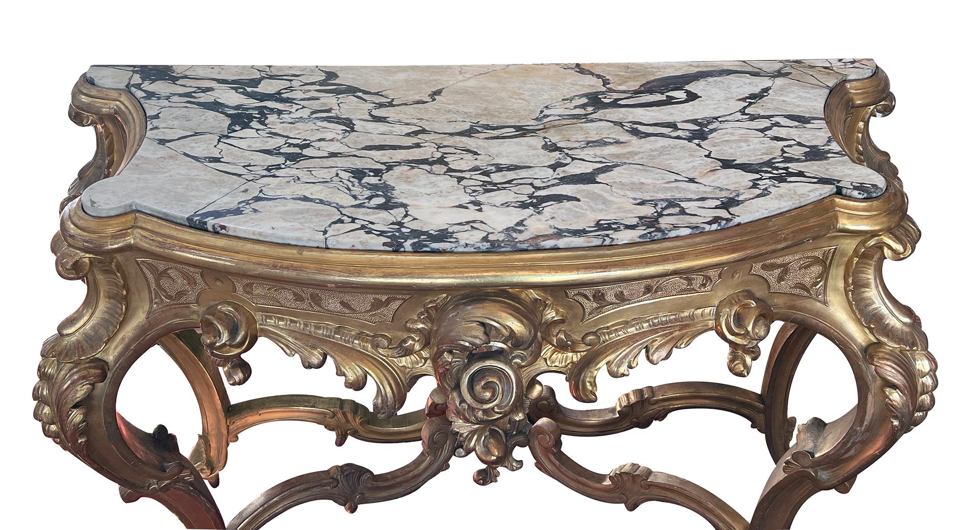 the Calacatta Viola marble top with bowed front and concave sides inset within an ogee molded edge; over a deep apron with rocaille and acanthus carving; raised on cabriole supports with similar rocaille and acanthus decoration with cascading bell