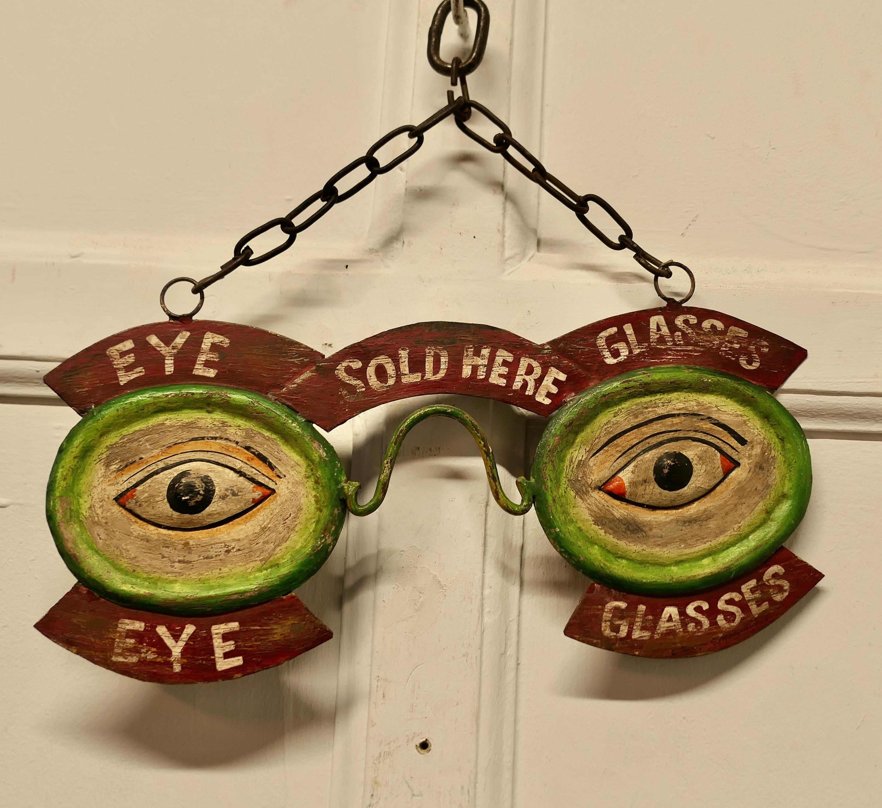 Eye and Glasses Window Display Trade Sign

The sign is made in presses tin, it seems to be hand painted with the slogan Eye Glasses Sold Here
The sign is a wall hanging piece suspended on a chain, it is 13” top to bottom and 14” across
TSC178