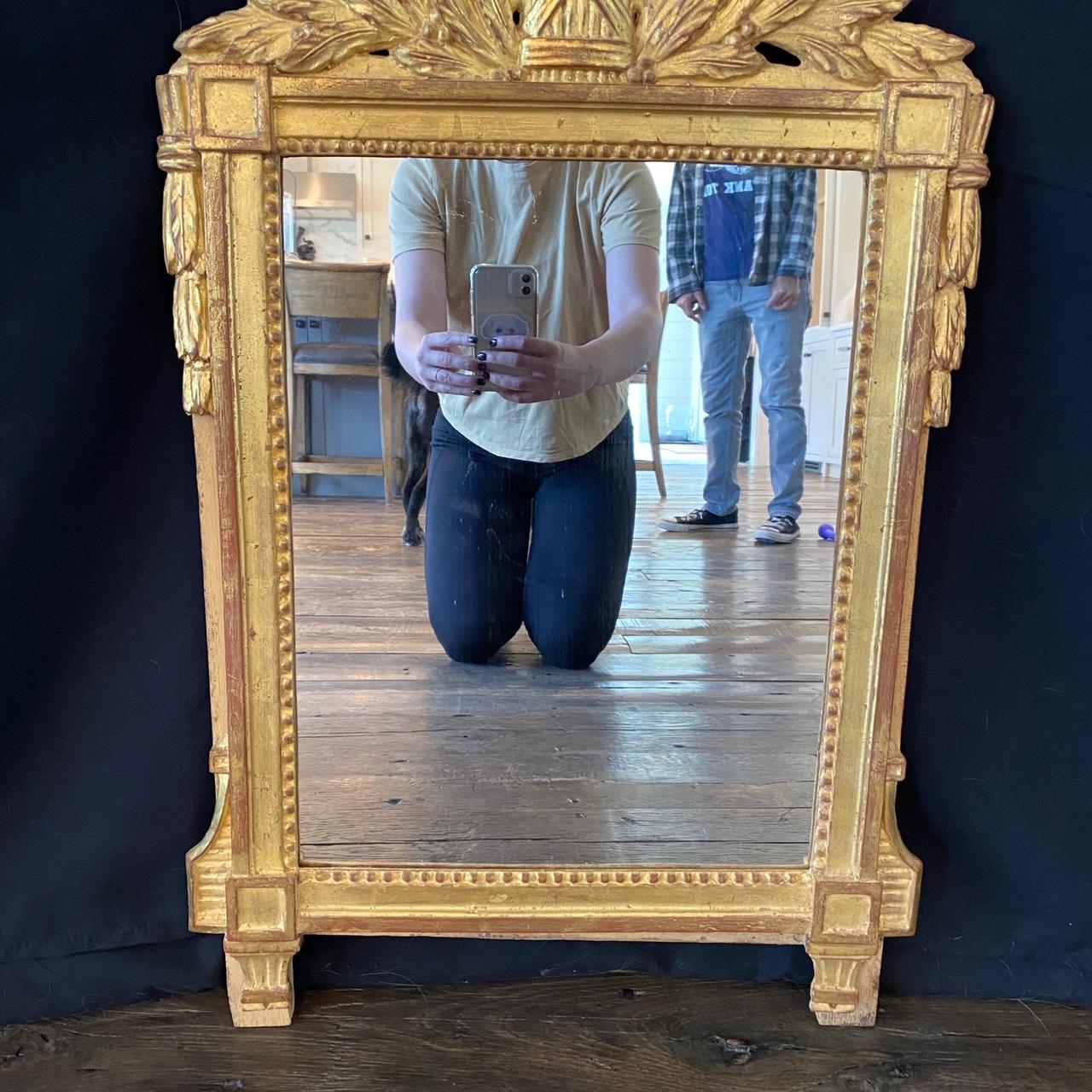 Miroir français du début du XIXe siècle orné d'acanthes, avec dorure d'origine et verre de miroir neuf. La couronne supérieure est une couronne de feuilles d'acanthe surmontant un fourreau de blé couronné d'un casque de guerrier et de haches