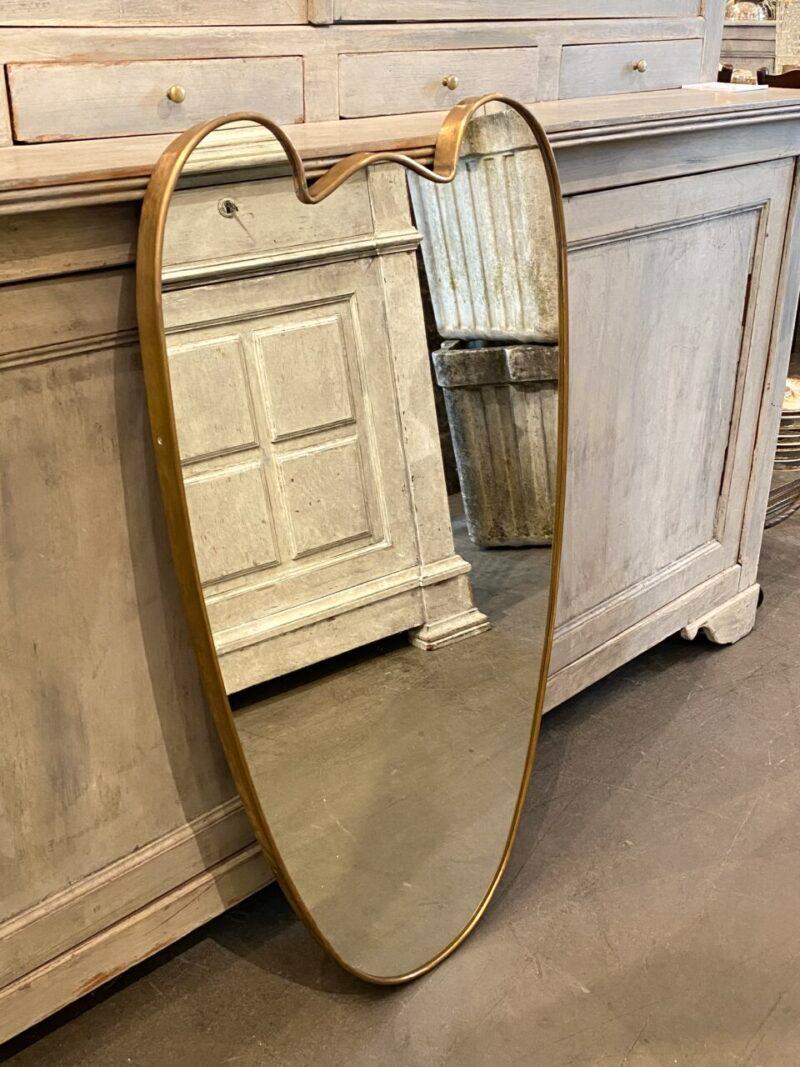 Stunning brass mirror, from Italy circa 1950s, in a beautiful design. Original mirrored glass, and stylistically related to the well-known designer Giò Ponti’s design. The mirror has suspension brackets mounted on the back.

Notice the elegant wide