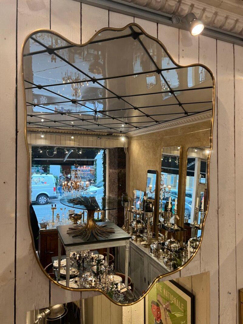 Merveilleux miroir italien du milieu du siècle, au design magnifique.

Miroir en verre original et stylistiquement apparenté aux célèbres conceptions de Giò Ponti.

Des éléments de suspension sont montés à l'arrière.

Notez l'élégant profil large en