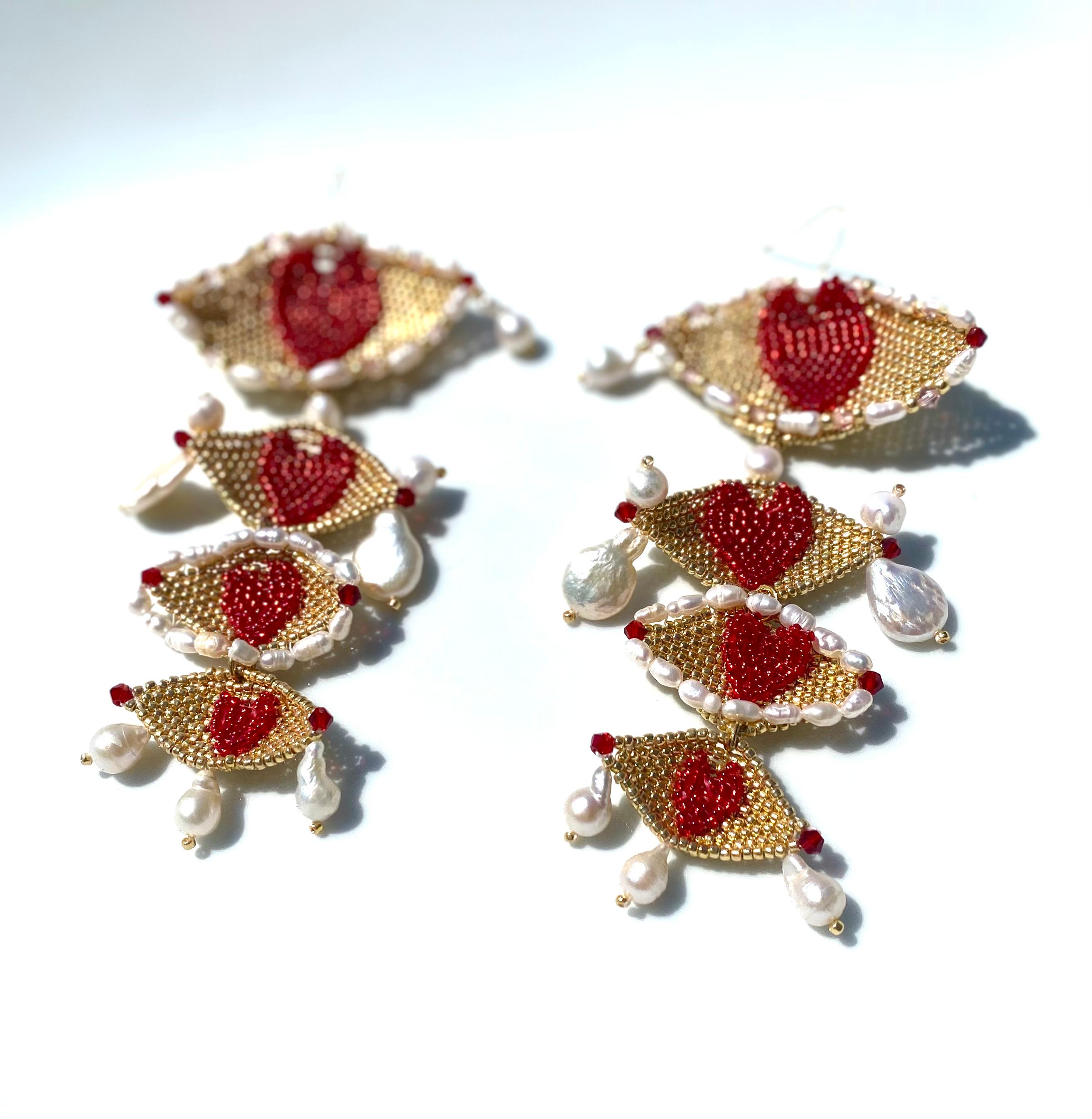 Inspired by Salvador Dali's, The Eye of Time this earring consists of four hand woven eyes shapes in permanent gold plated seed beads with scarlett red hand woven hearts as the pupils. Each woven eye is embroidered with Swarovski Crystals in red,