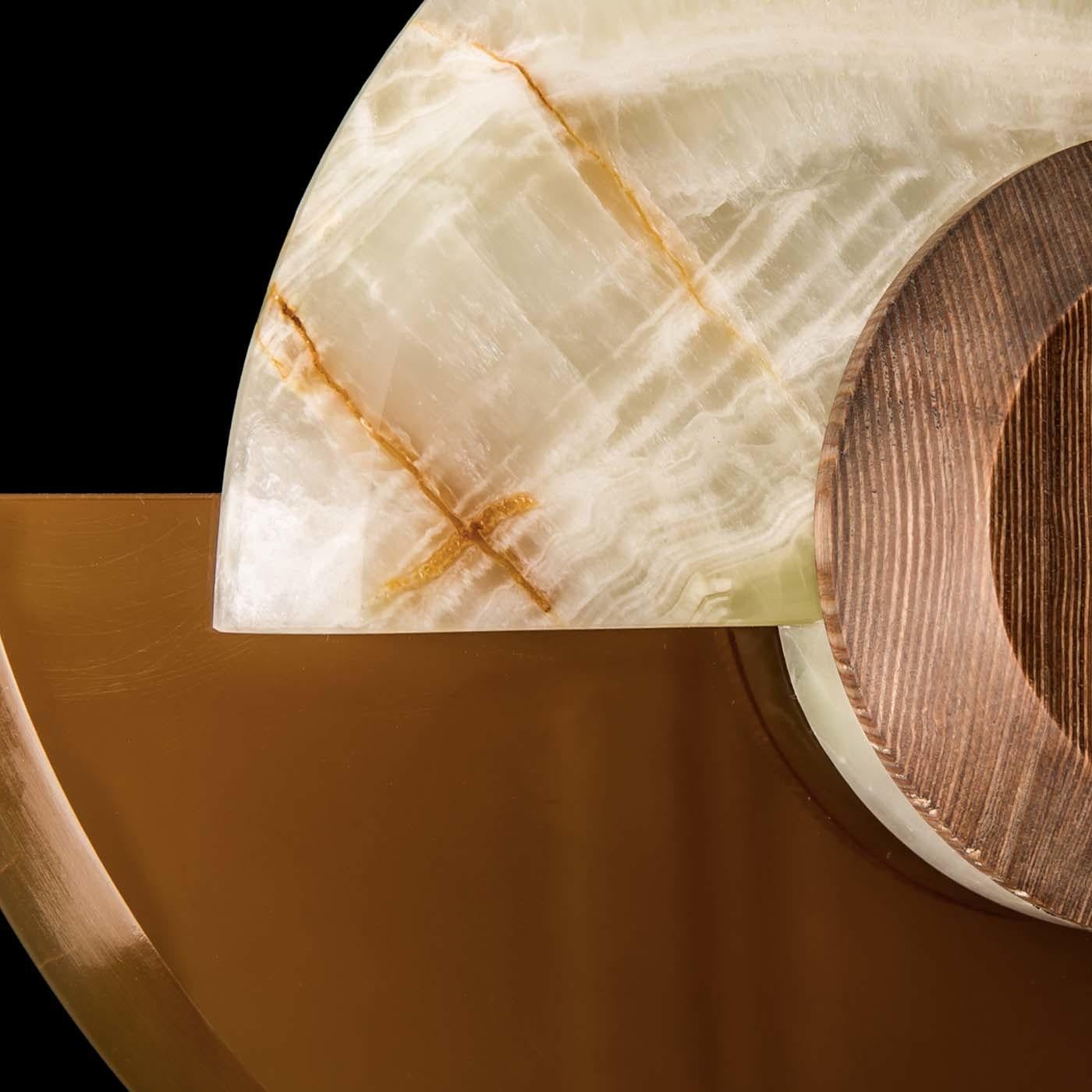Part of the Eye collection of home decor pieces with a striking shape that evokes the silhouette of an eye, this sconce is a bold combination of high density wood (a very resistant material with a warm look) and two types of onyx: green glory and
