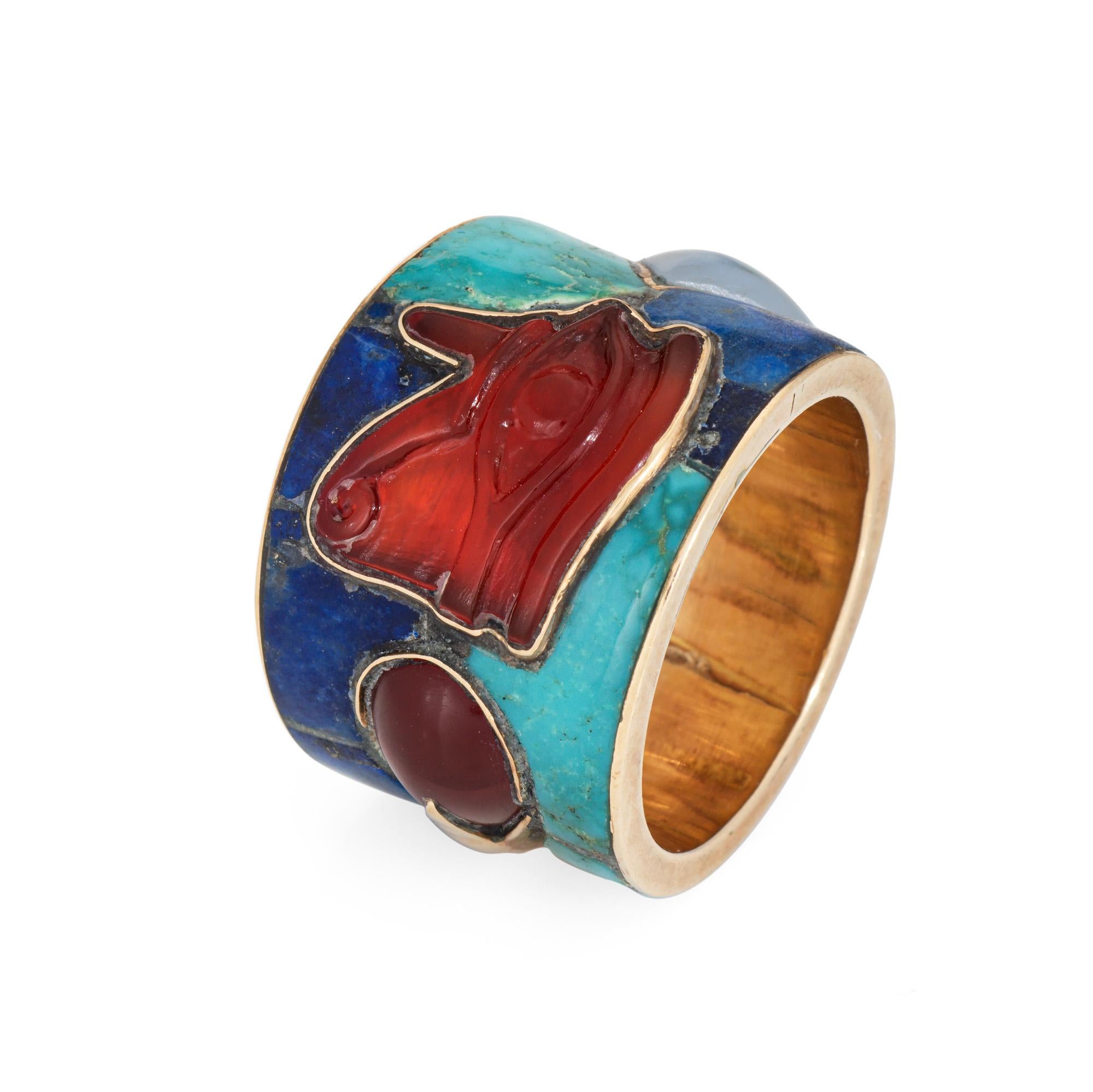 Finely detailed 'Eye of Horus' ring crafted in 14 karat yellow gold (circa 1970s to 1980s).

Turquoise & lapis are inlaid into the band. The Eye of Horos is inlaid with carved carnelian with accenting chalcedony and carnelian. Note: few fissures to
