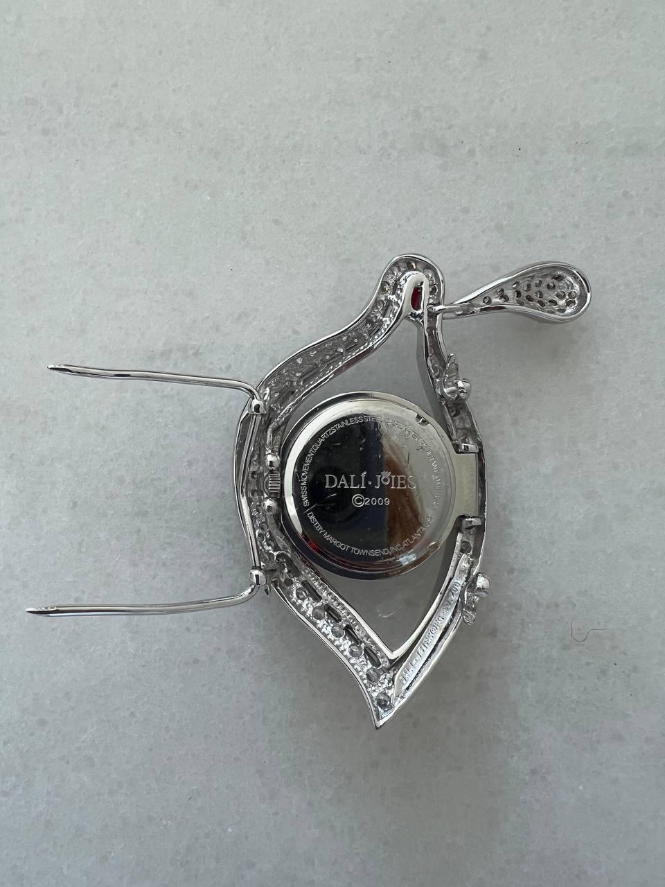 Brooch designed by Salvador Dali in the form of eye centered with a watch. Embedded with rhinestones. 
Year: 2009 
Condition: very good

........Additional information ........

- Photo might be slightly different from actual item in terms of color