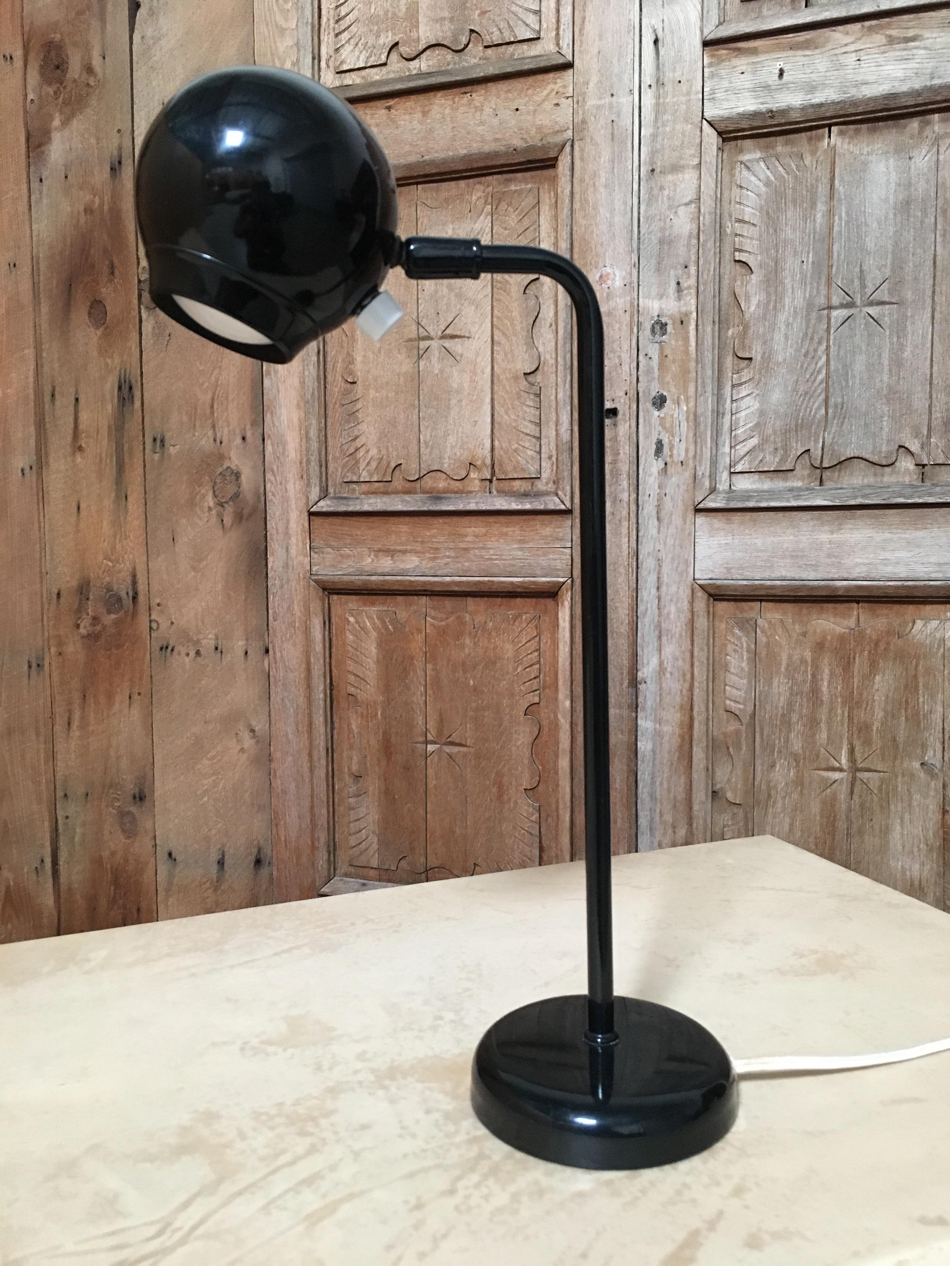 A desk or table lamp with black enamel finish task lighting label with Kovacs name.
   