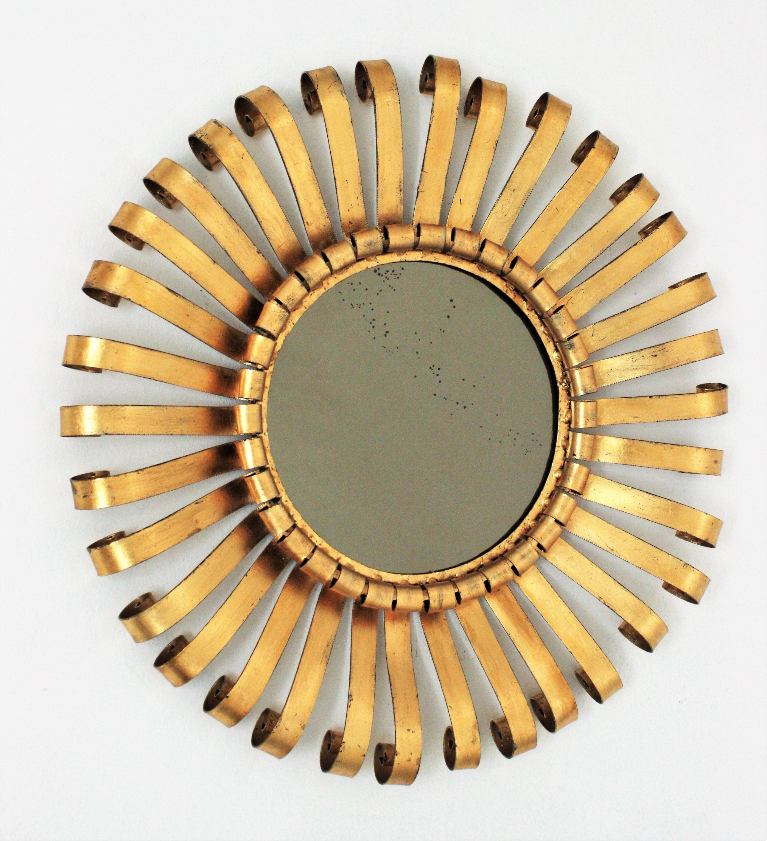 Miroir en fer forgé brutal en forme de soleil, Espagne, années 1960.
Ce miroir en fer forgé à la main possède une structure en fer forgé à la main avec des poutres terminées par des volutes et finies par une dorure à la feuille d'or. Une pièce