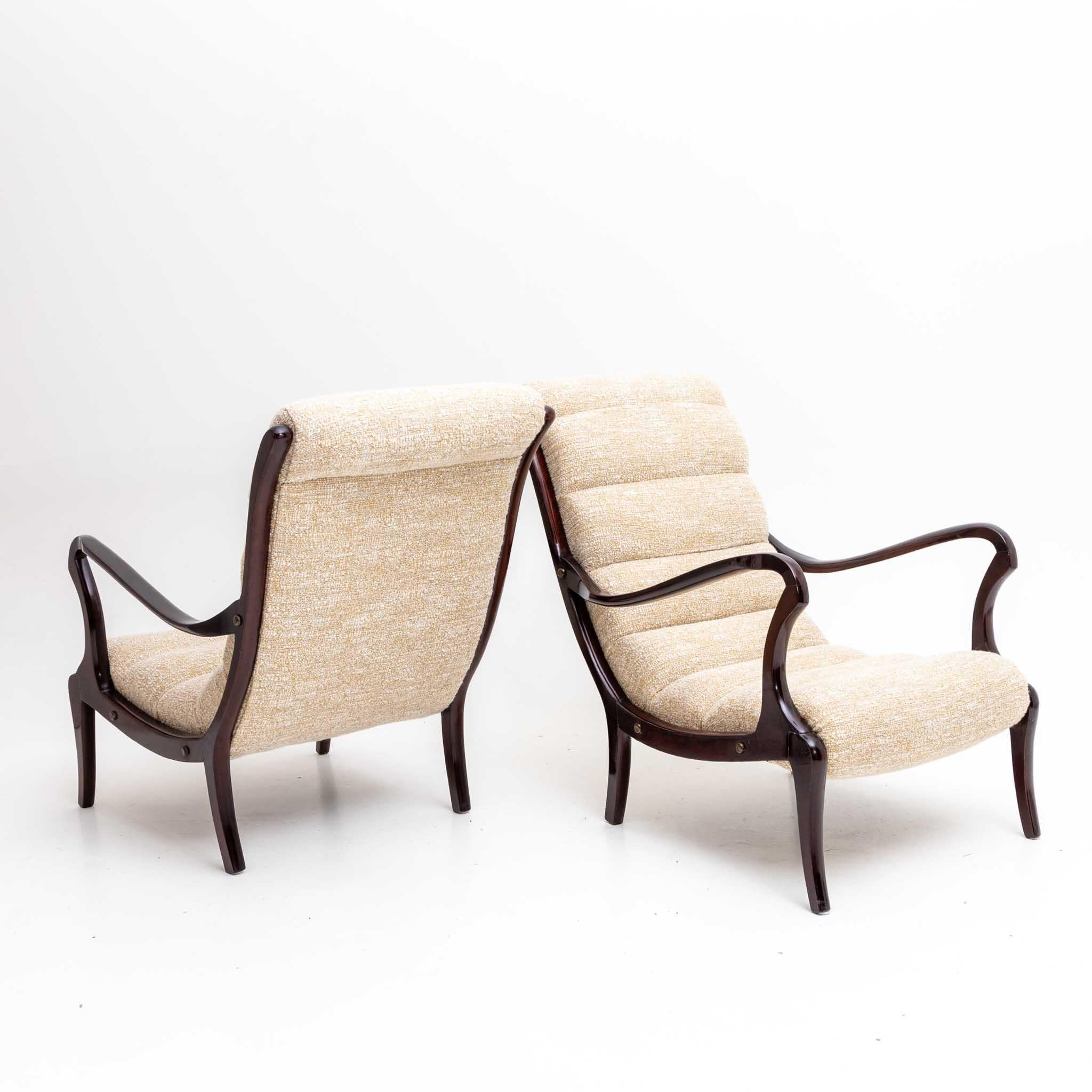 Pair of armchairs by Ezio Longhi with elegant dark stained wooden frames and beige upholstery.