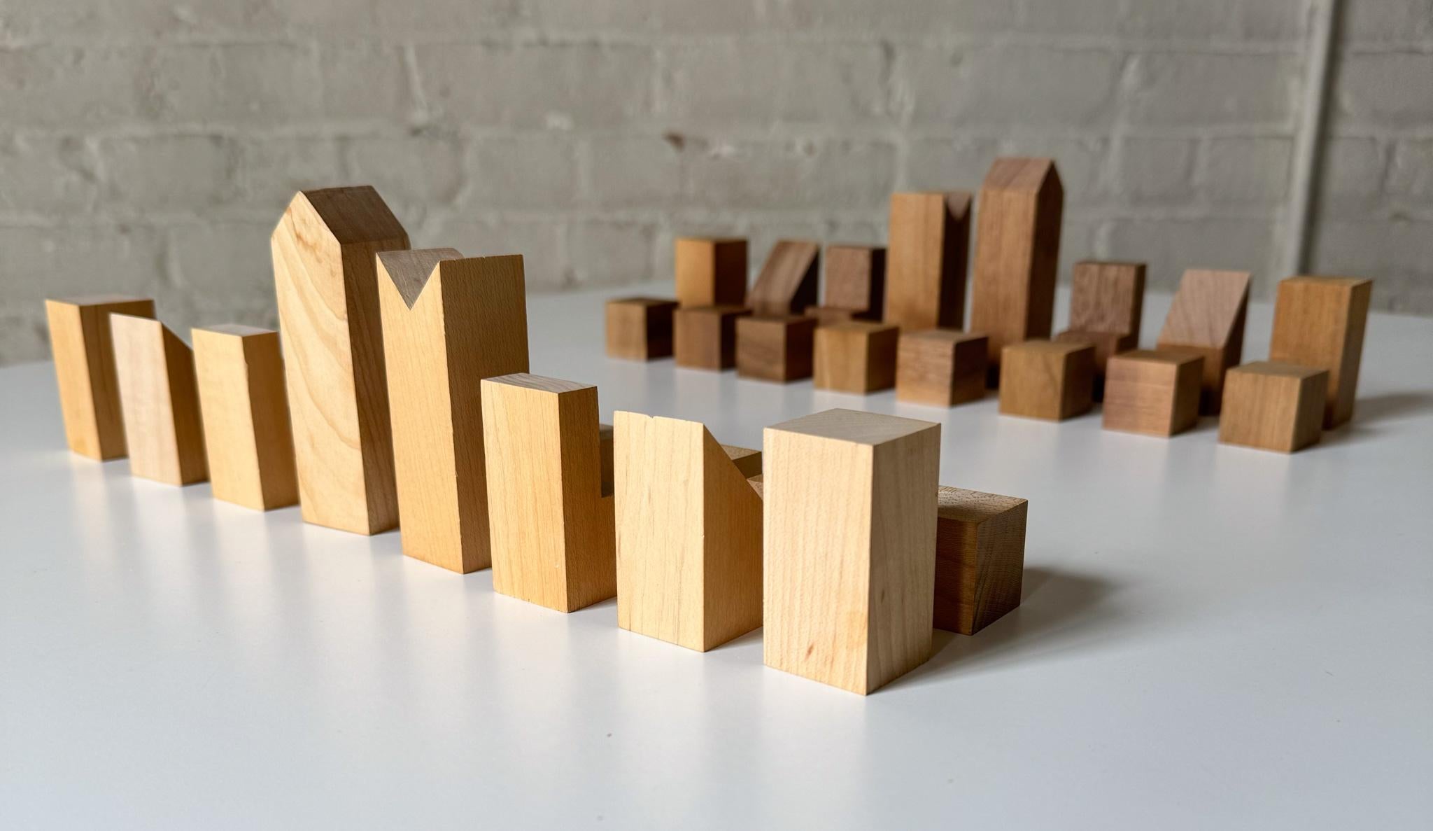 Minimalist chess set in walnut and korina (white limba) wood by American sculptor, museum curator, art historian, and chess aficionado F. Lanier Graham. Issued by the Museum of Modern Art in 1966, and now part of its permanent collection.  The