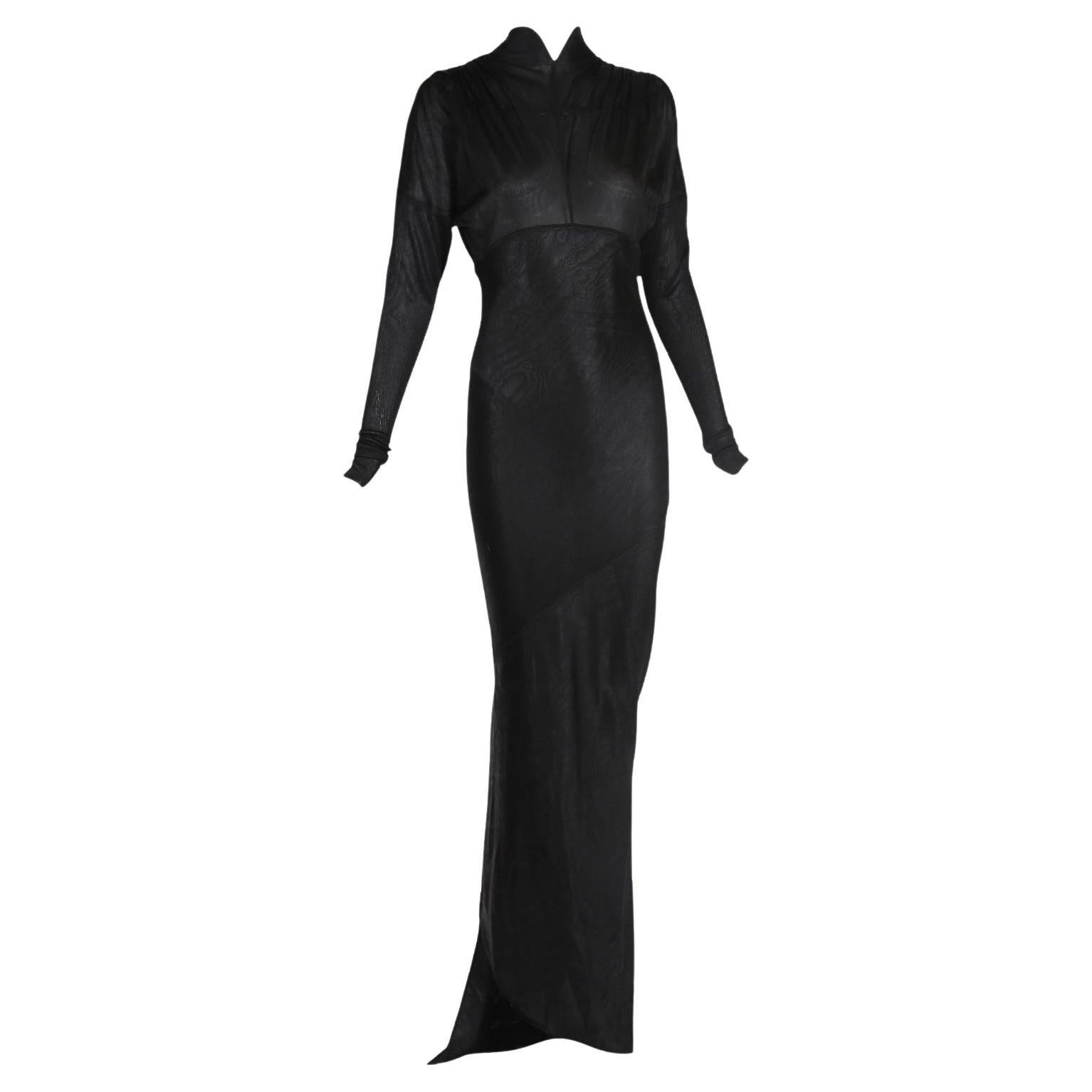 F/W 1988-89 Azzedine Alaia vestido de noche ceñido al cuerpo, largo hasta el suelo, en un tono negro tinta intenso con  Tren asimétrico en la espalda. Confeccionado con un grueso jersey de moaré de acetato, el vestido presenta un cuello mandarín