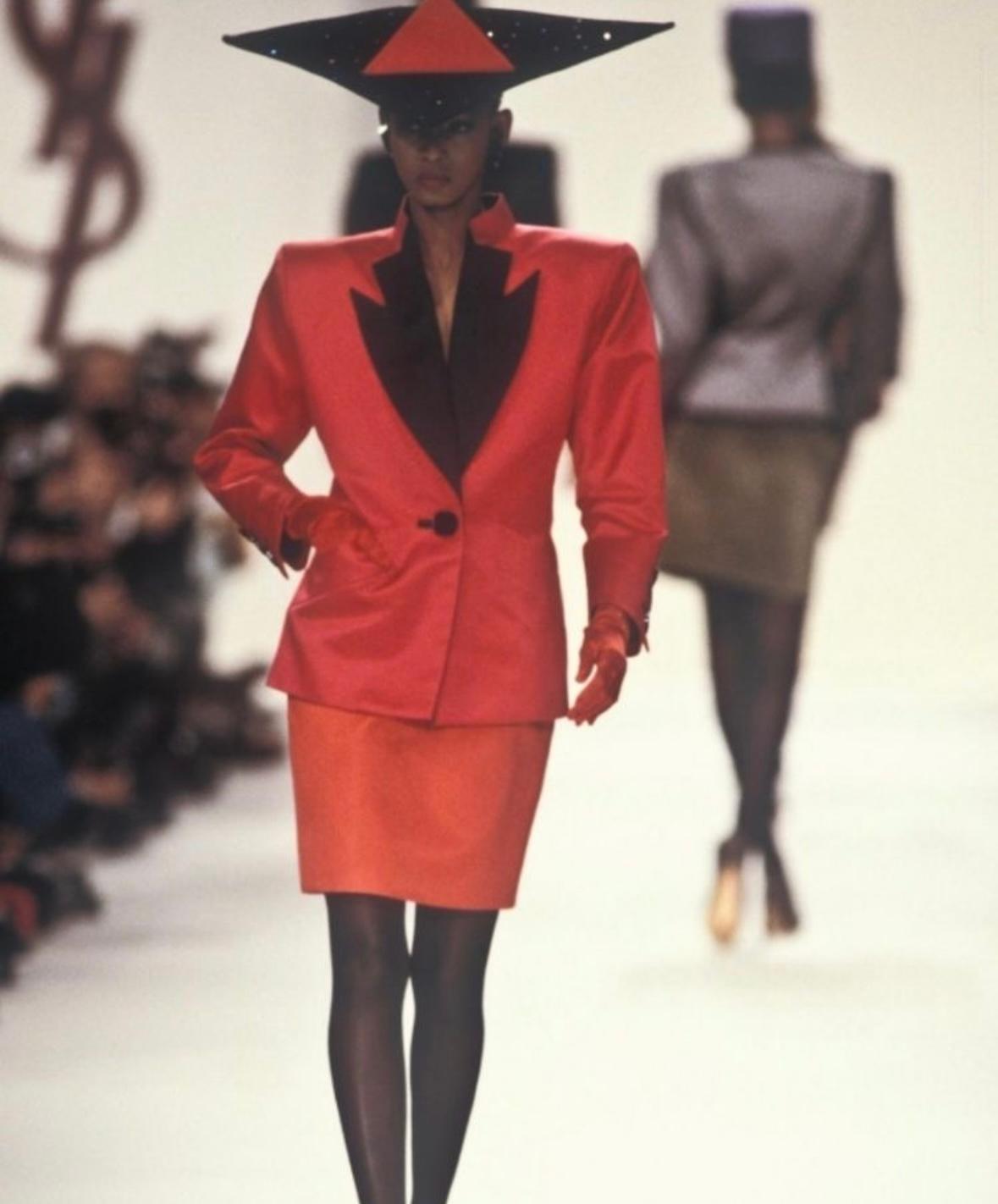Wir präsentieren einen auffälligen roten Satinrock, den Yves Saint Laurent für seine Herbst/Winter-Kollektion 1988 entworfen hat. Mehrere Versionen dieses klassischen Rocks wurden auf dem Laufsteg der Saison gezeigt. Die Taschen waren so platziert,