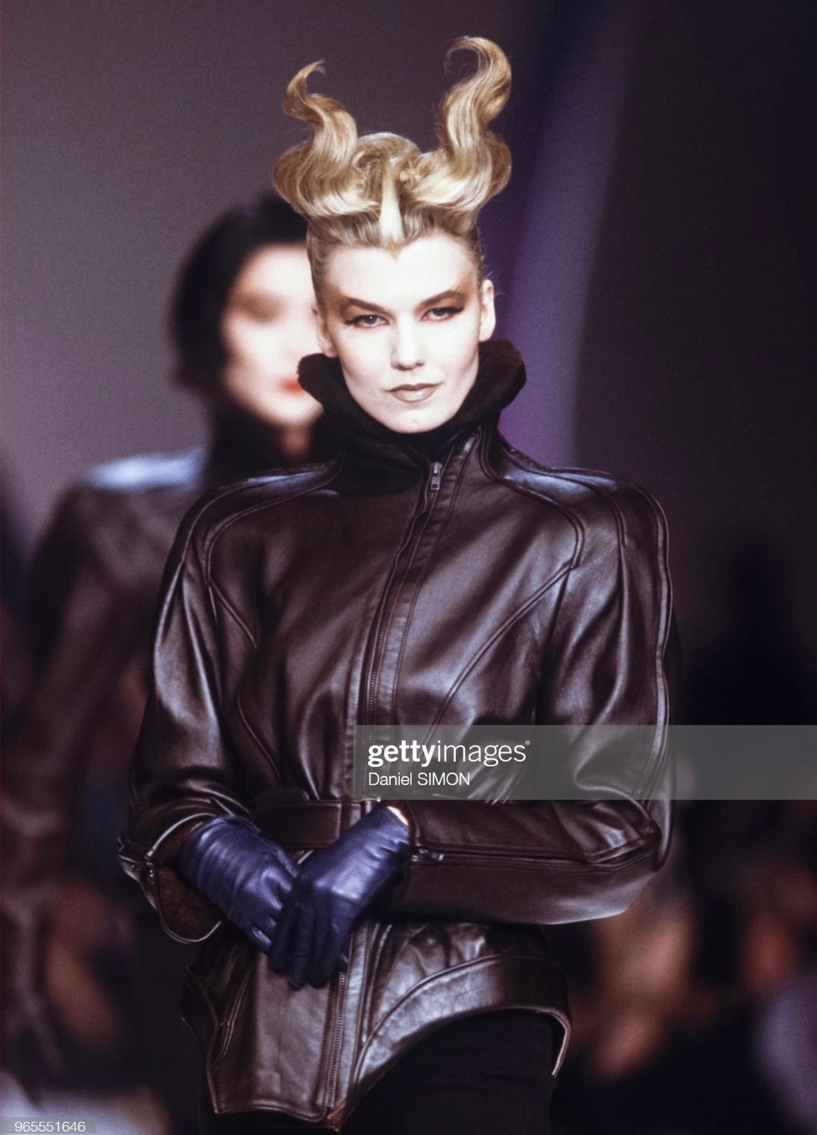 Te presentamos una fabulosa cazadora motera Thierry Mugler de cuero negro, diseñada por Manfred Mugler. De la colección Otoño/Invierno 1988 