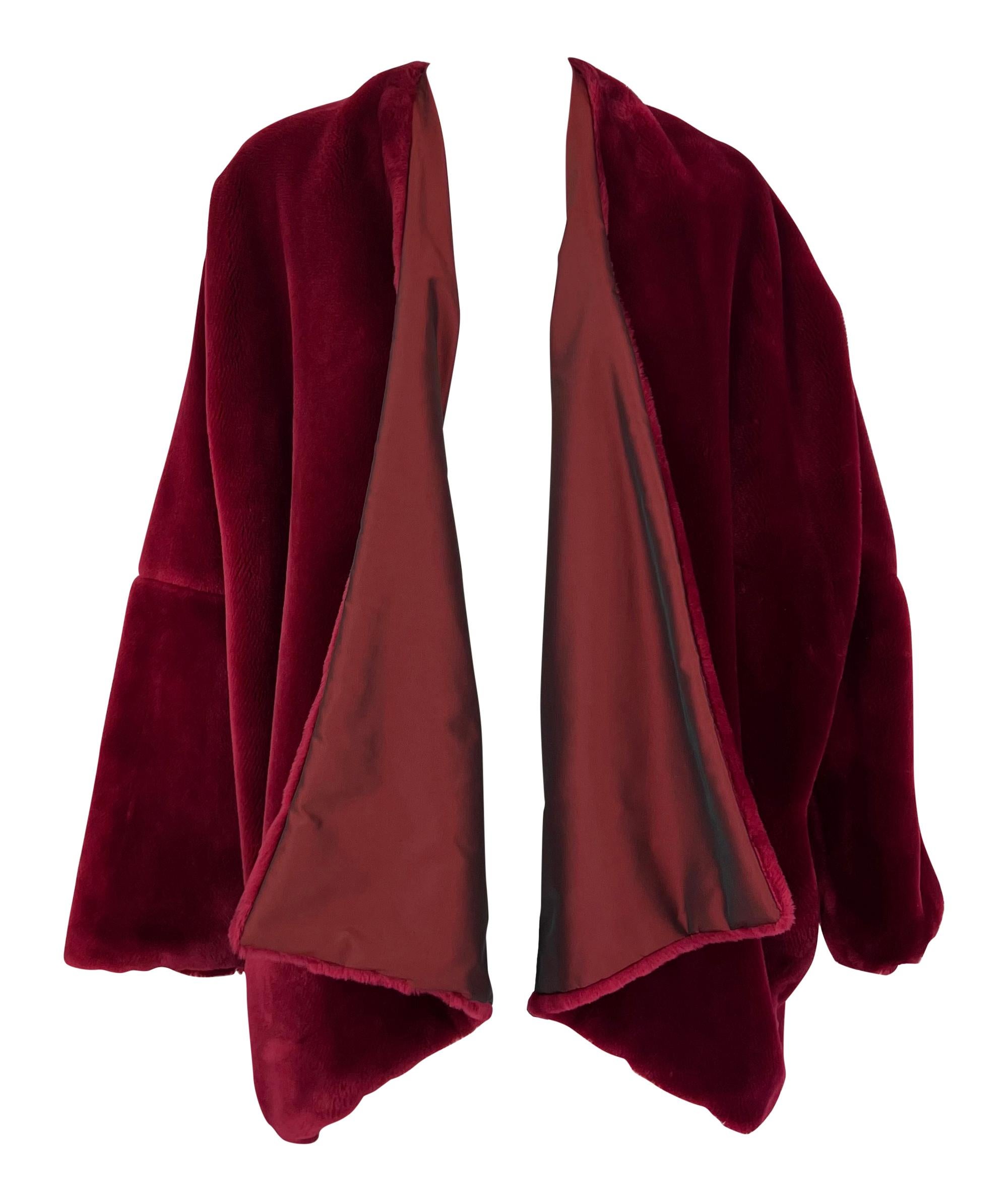 Questo cappotto a scialle oversize di Dolce & Gabbana della collezione Autunno/Inverno 1989 è realizzato in pelliccia sintetica rosso mirtillo. Il design aperto sul davanti è caratterizzato da una silhouette drappeggiata con una morbida fodera in