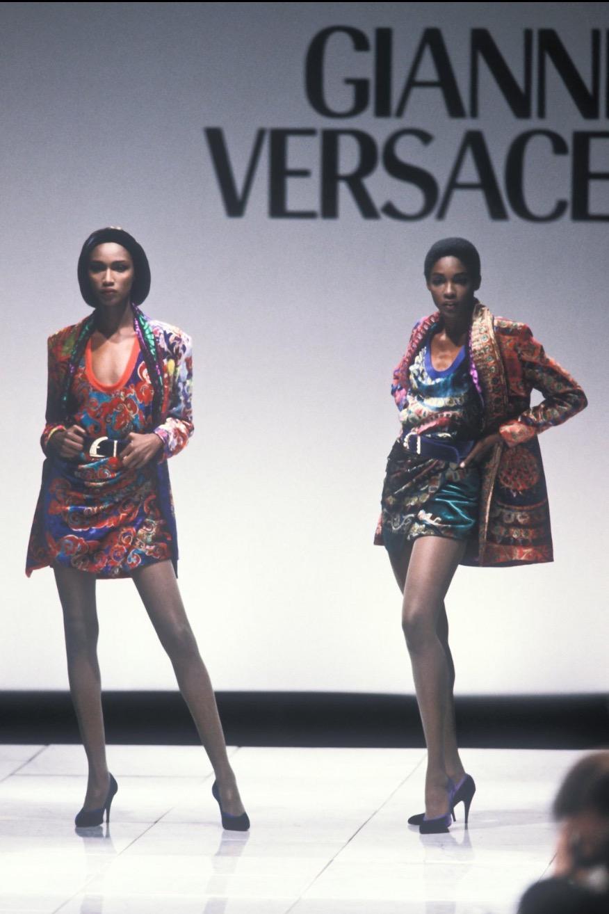 Esta falda de terciopelo multicolor de la colección Otoño/Invierno 1990 de Gianni Versace presenta un llamativo e intrincado estampado. Este rico estampado debutó en la pasarela de la temporada, el diseño combina atrevidos motivos circulares en
