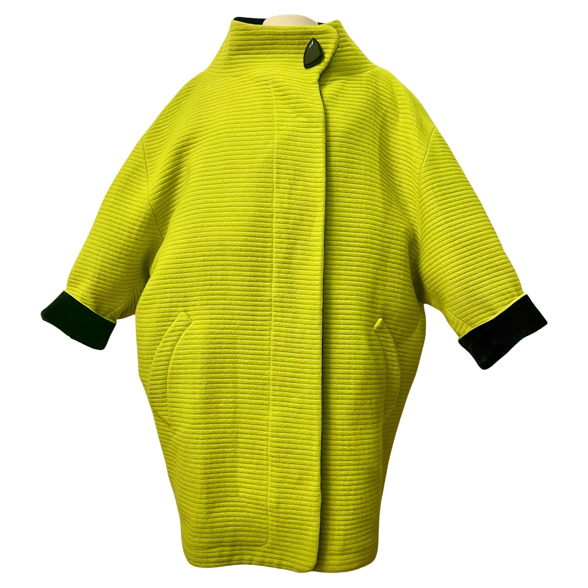 Llama la atención con este asombroso y vanguardista abrigo capullo de lana de Thierry Mugler de Otoño/Invierno de 1990. Este abrigo verde lima vivo, increíblemente raro, tiene un diseño futurista con un amplio cuello de embudo que crea un