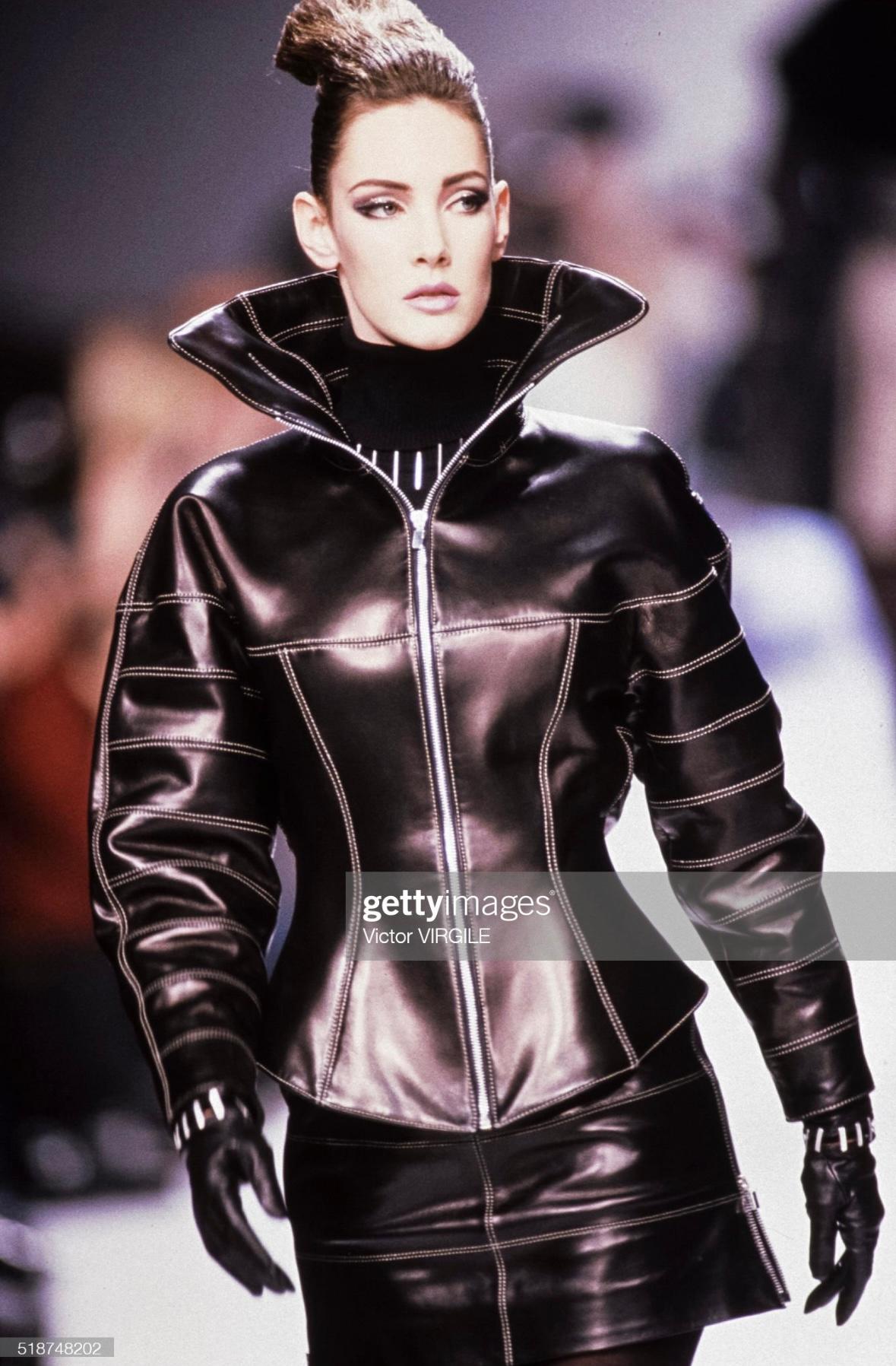 Presenting an incredible black leather Claude Montana moto jacket skirt suit set. From the Fall/Winter 1991 collection, this set made its debut on the season's runway. Crafted entirely from black leather, the set consists of a mini skirt and a