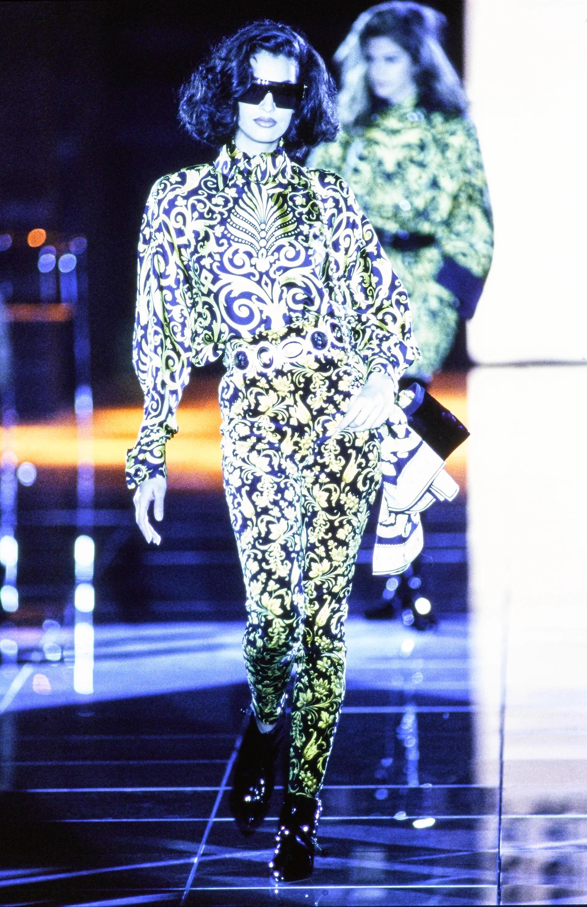 Presenting a fabulous pair of black-yellow-gold baroque print Gianni Versace velvet print, designed by Gianni Versace. From the Fall/Winter 1991 collection, these pants debuted on the season's runway as part of look 65, modeled by Yasmeen Ghauri.