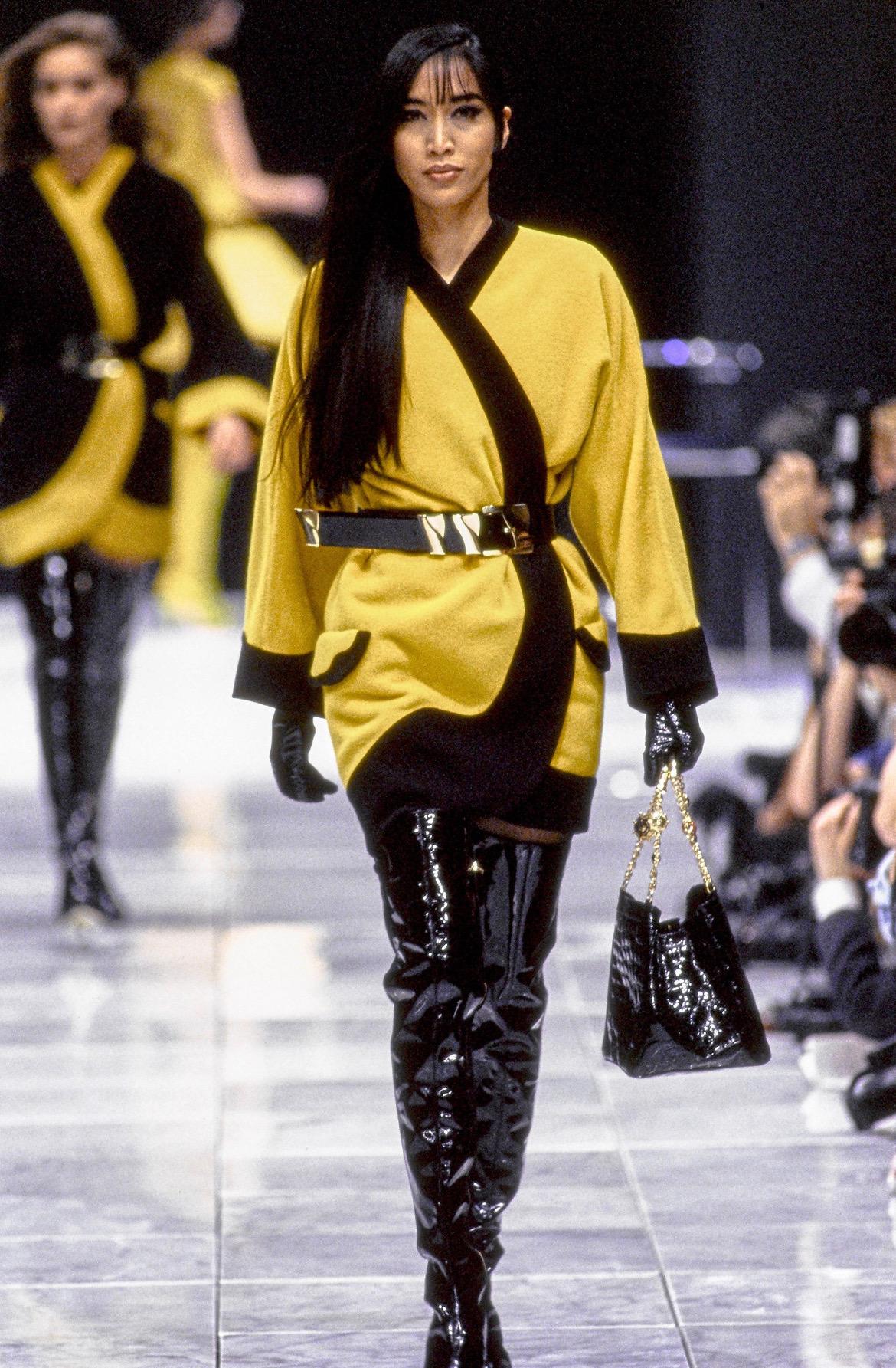 Presenting a fabulous yellow oversized Gianni Versace wrap coat designed by Gianni Versace. From the Fall/Winter 1991 collection, this coat debuted on the season's runway as part of Look 17. This incredible oversized coat features contrasting black