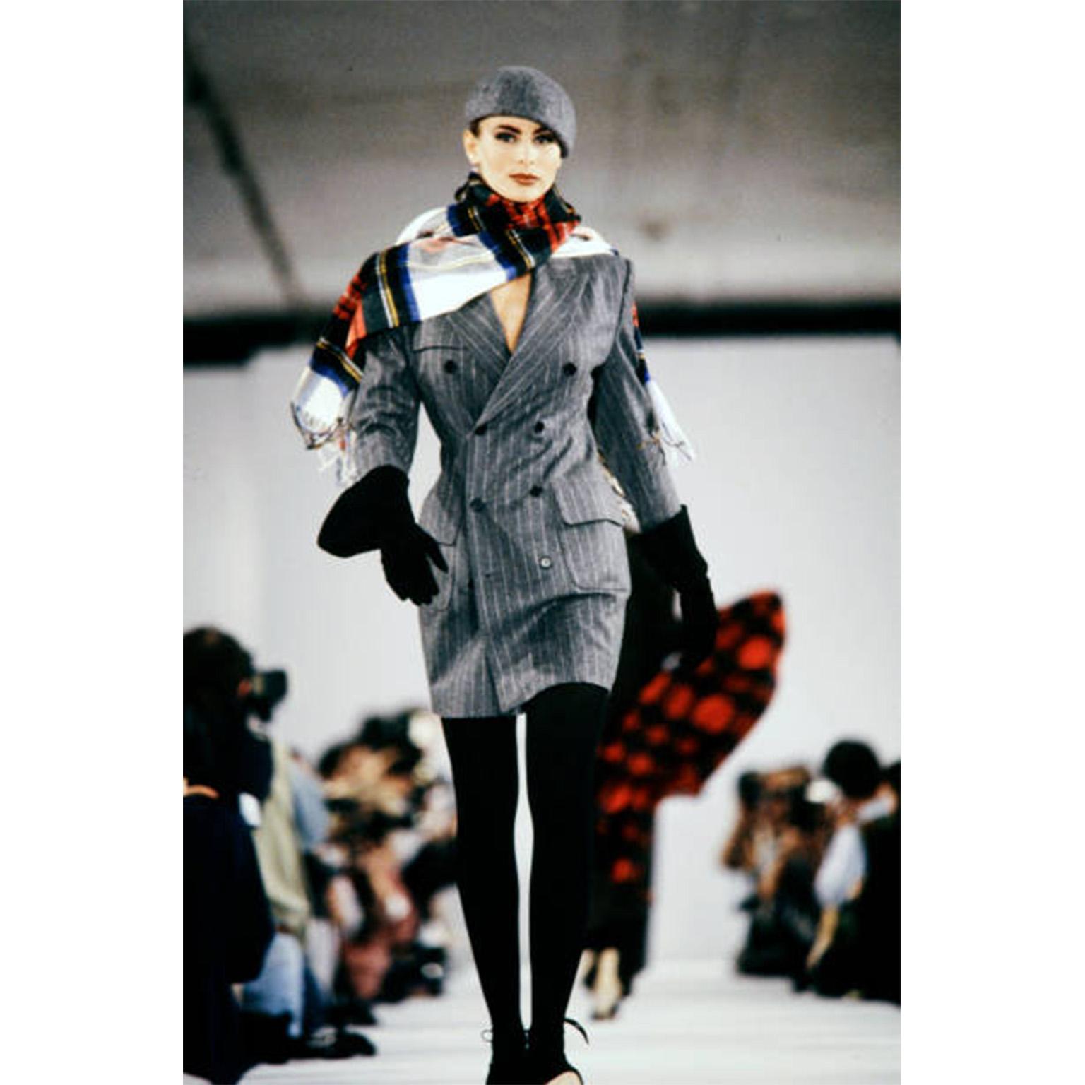 This vintage Isaac Mizrahi coat dress is in a grey pinstripe wool. The dress was featured on the Isaac Mizrahi Fall Winter 1991 runway and we are showing an image from that show with Nikki Taylor. The dress could also be worn as a jacket or coat and