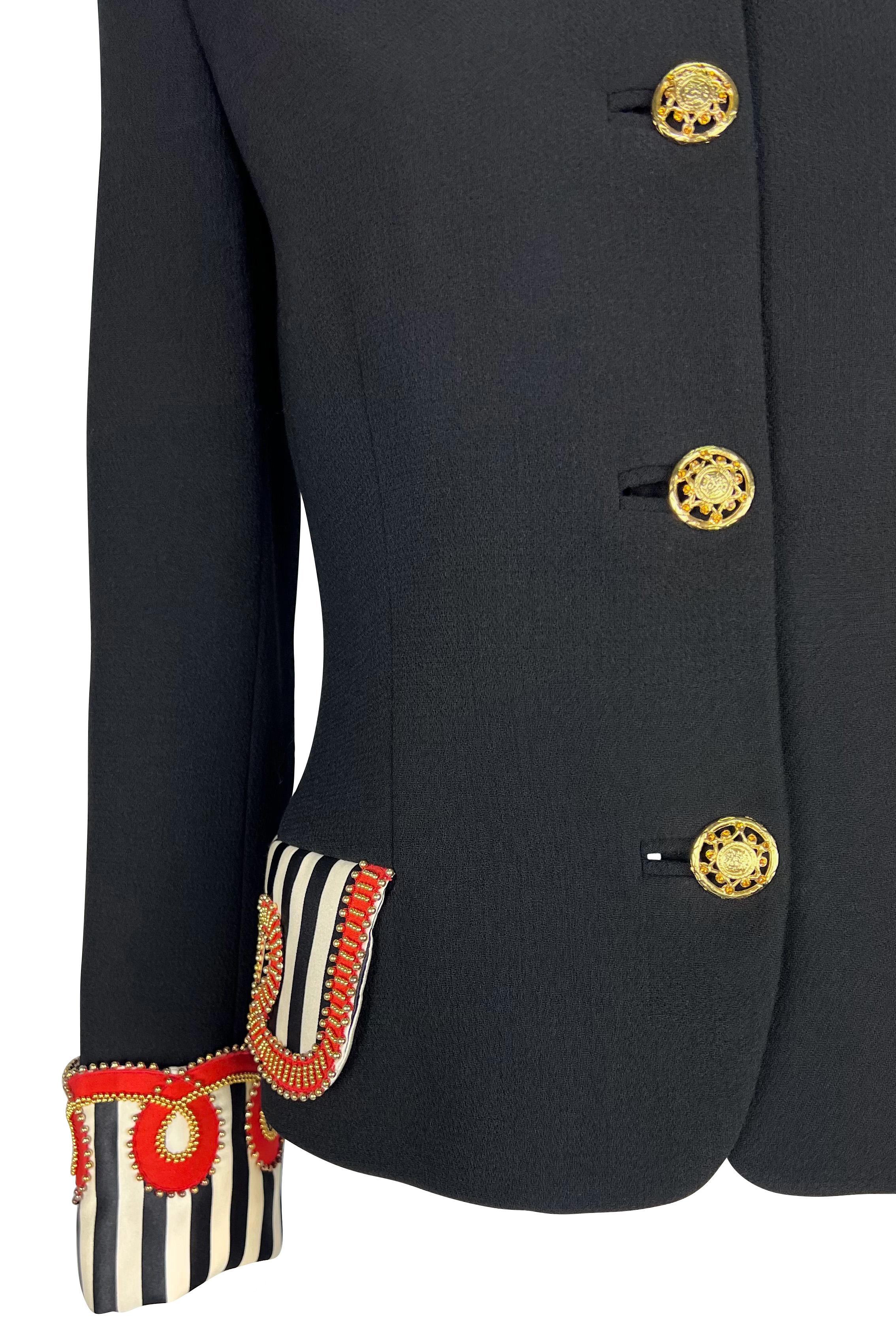 Gianni Versace designed this stunning black studded jacket for his brand's Fall/Winter 1992 'Miss S&M' collection. This chic, collarless jacket features rhinestone-accented gold Versace Medusa buttons at the front. The look is enhanced by black and